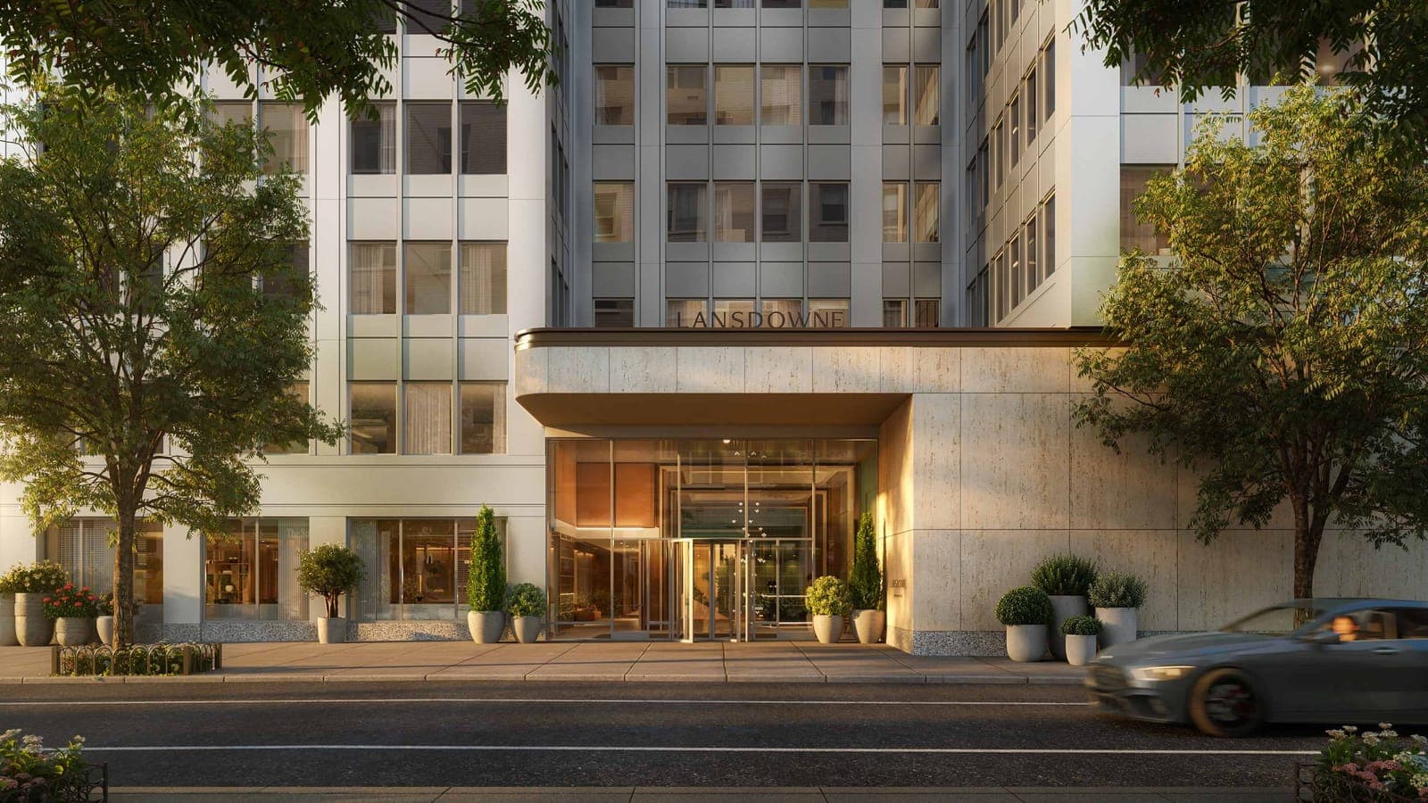 Rendering of a street-level entrance with a stone canopy lettered Lansdowne, glass doors, planters and trees below a pale office-style tower