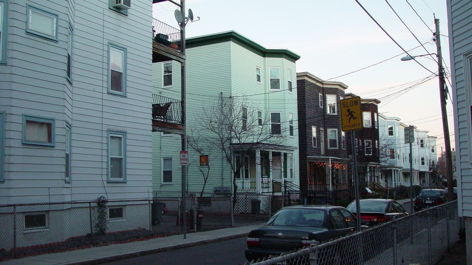 Triple-decker houses along a residential street in Cambridge, Massachusetts