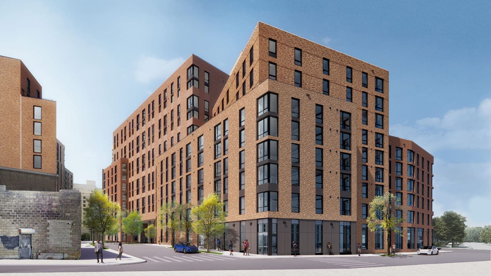 Rendering of a red-brown brick apartment building on a street corner, stepping up from a lower corner section to taller wings behind, with dark-framed corner windows, a gray ground floor with glass storefronts, young street trees, a parked blue car and people on the sidewalk