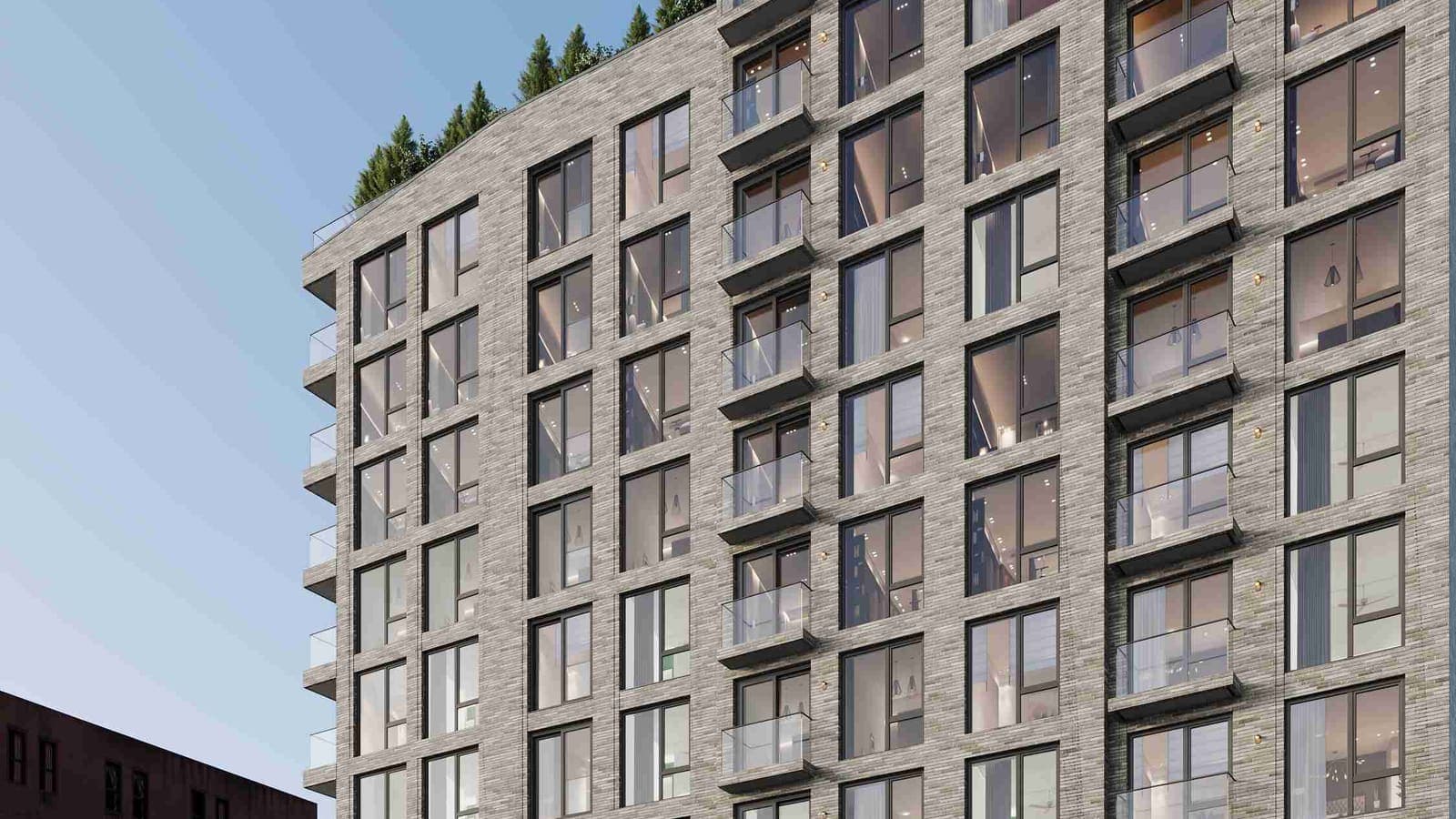 Rendering of the upper floors of a grey brick apartment building with large windows, glass balconies and trees along the roofline