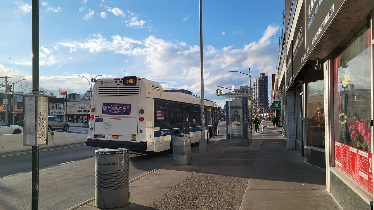 Sidewalk, storefronts and a bus stop on Queens Boulevard near 78th Avenue and Union Turnpike.