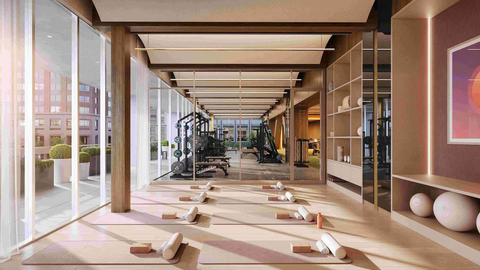Rendering of a yoga area with mats on a wood floor, opening onto a gym with weight machines and floor-to-ceiling windows