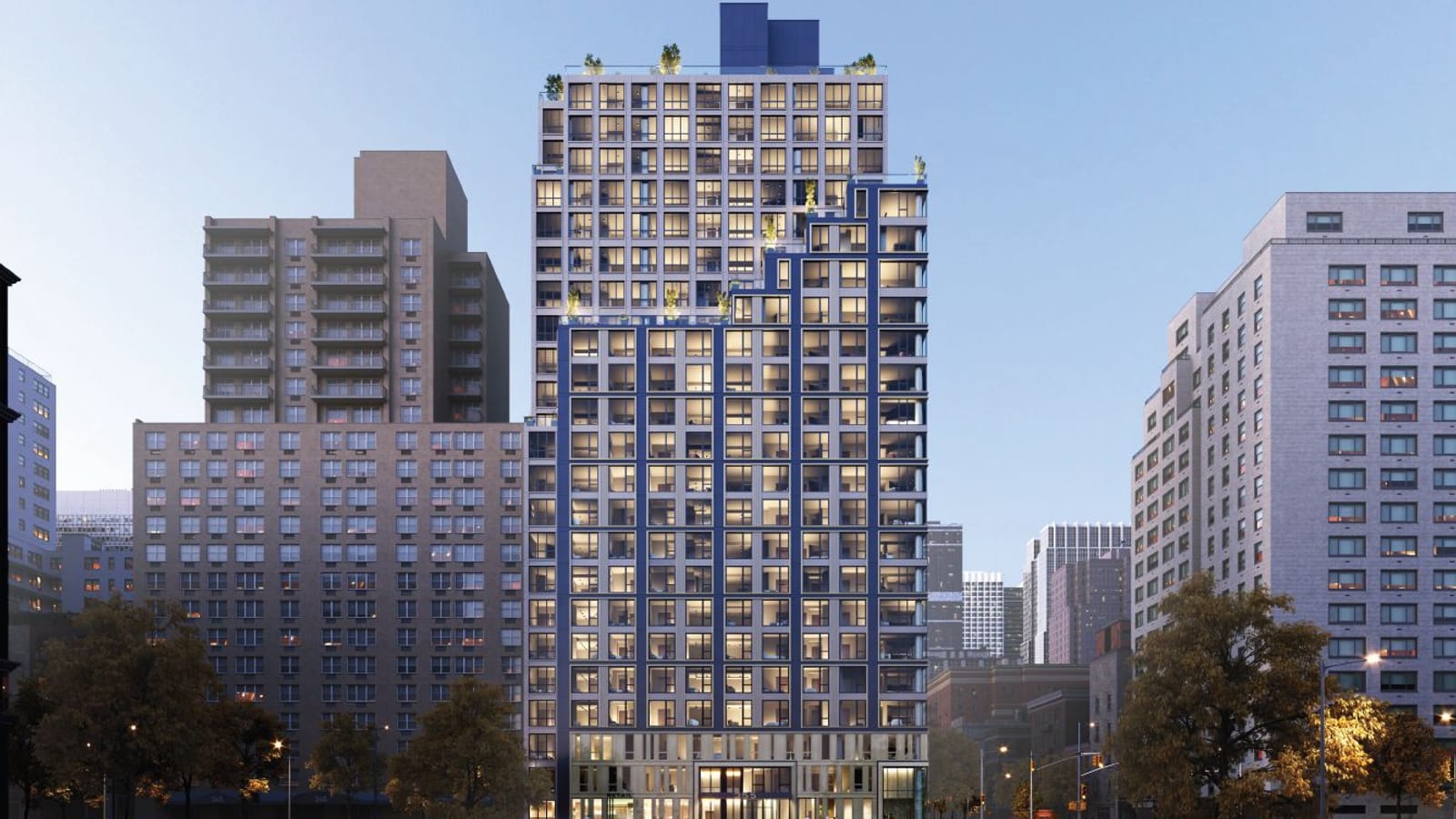 Rendering at dusk of a 23-story apartment tower: a lower section clad in dark blue panels that steps back in terraces toward the right, lighter gray upper floors with a dark blue box on the roof, a glass ground floor, and older brick and pale apartment buildings on both sides behind autumn trees