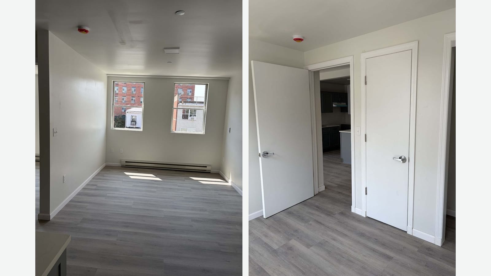 Two photographs side by side of empty rooms with gray plank floors and white walls: on the left, a room with two windows looking out at a red-brick apartment building and a white-sided house, with a long baseboard heater under the windows; on the right, a bedroom with an open door to a kitchen with dark gray cabinets and a closed closet door