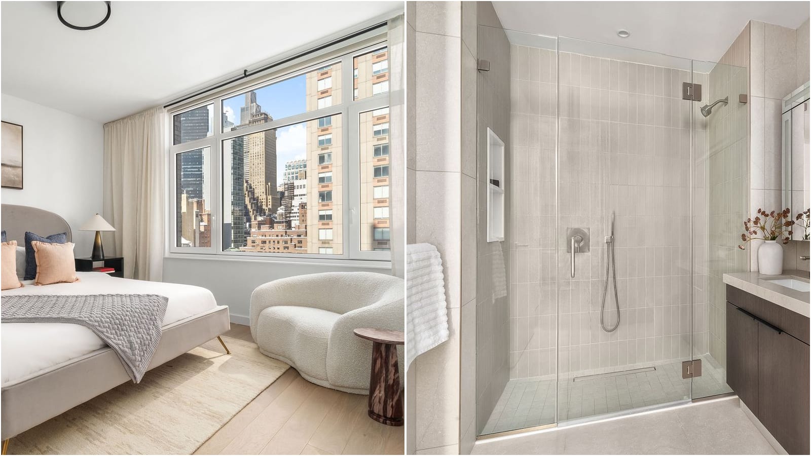 Two photographs side by side: at left a bedroom with a grey upholstered bed, a white curved armchair and a wide window looking at Midtown towers; at right a bathroom with a glass-enclosed walk-in shower, pale vertical tile, a wall niche, a hand shower and a dark wood vanity