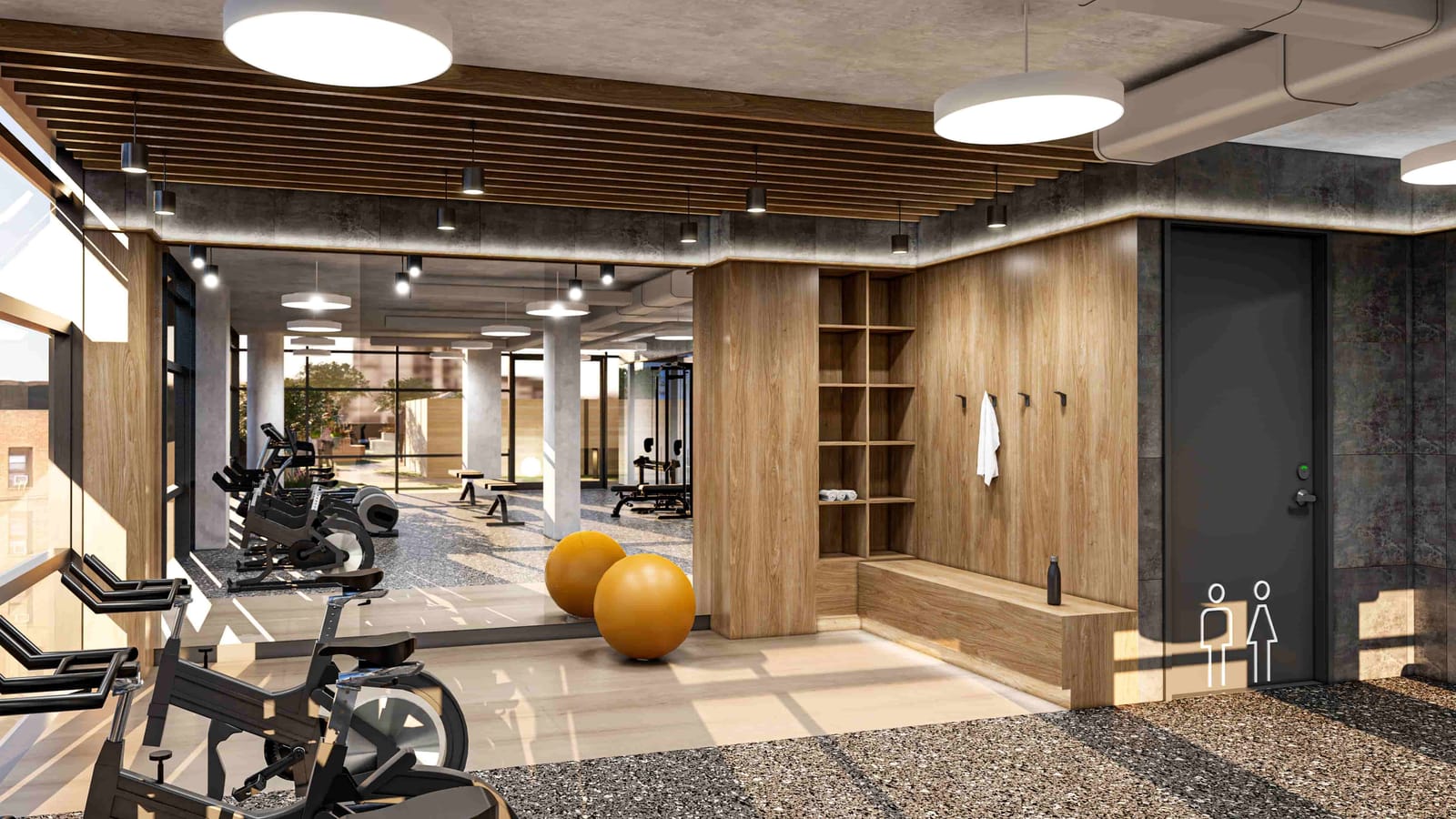 Rendering of a gym with exercise bikes along a window wall, two orange exercise balls, wooden cubbies and coat hooks, a mirrored wall reflecting weight benches and machines, and a restroom door at right