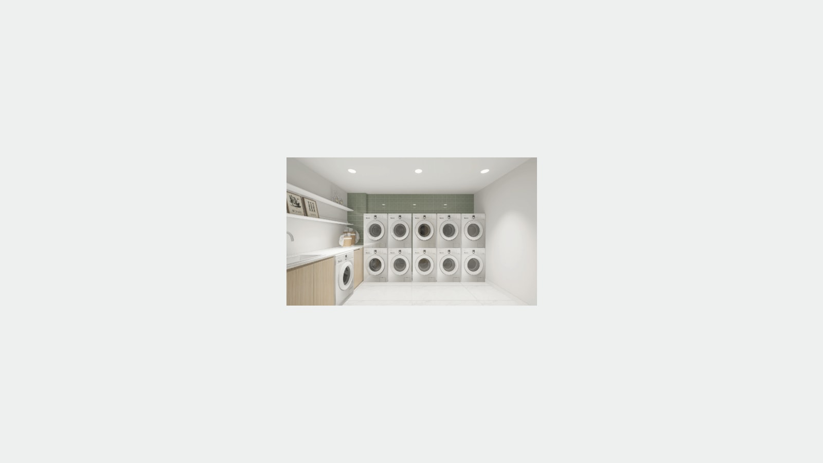 Rendering of a laundry room with ten stacked white washers and dryers against a green tiled wall, a counter with a sink and one more washer at left, and shelves with framed pictures
