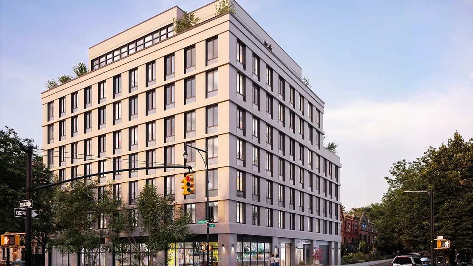 Rendering of an eight-story apartment building on a street corner at dusk: pale gray panels in horizontal bands, rows of dark-framed windows, a set-back top floor with plants, glass shopfronts at street level, a traffic signal and green street signs in front