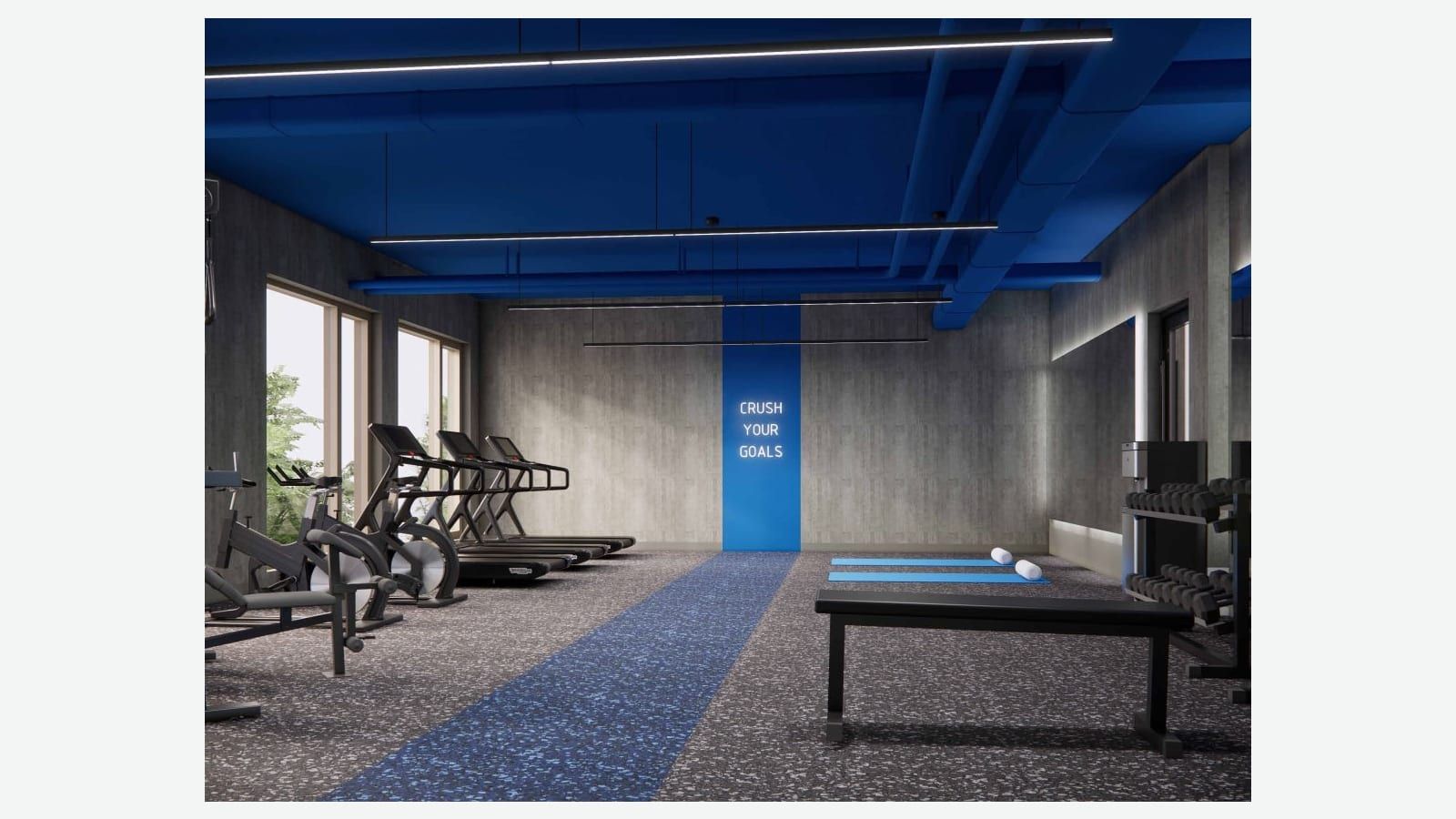 Rendering of a gym with a bright blue ceiling and exposed blue ducts, three treadmills and two exercise bikes by tall windows at left, a blue rubber floor strip, a lit sign reading Crush Your Goals on a blue wall panel, two blue yoga mats, a black bench and a dumbbell rack at right