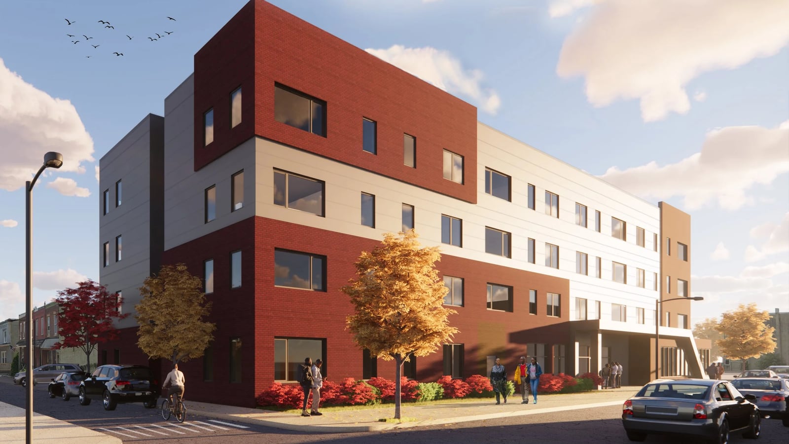 Rendering of a four-story apartment building with dark red brick and pale gray panels, a covered entrance on the long side, street trees with autumn leaves, parked cars and people on the sidewalk