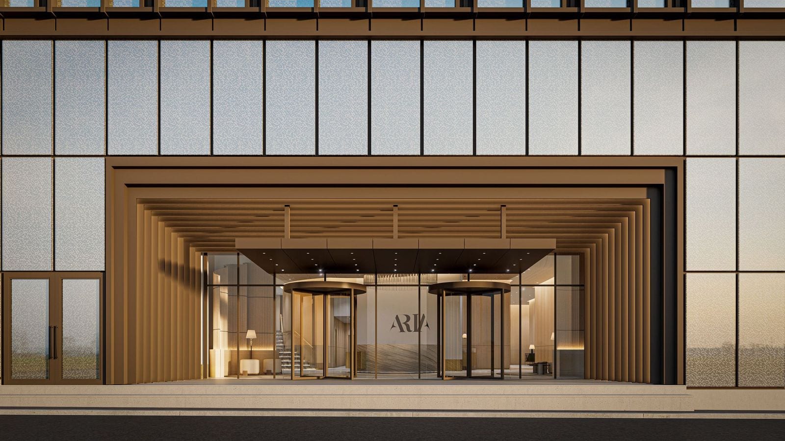 Rendering of a building entrance at street level: a deep bronze-colored portal with stepped ribs and a flat canopy over two revolving doors, the word ARIA on a wall inside a lit lobby, and panels of pale patterned glass around and above the portal