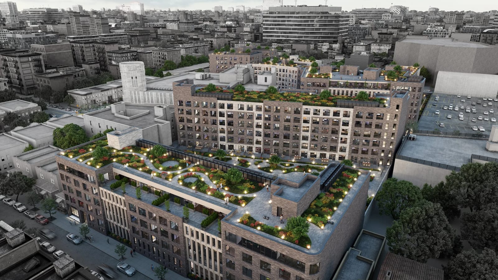 Aerial rendering at dusk of two connected seven-story brick apartment buildings with planted, lit roof terraces joined by a bridge, a street with parked cars at the lower left, a pale tower lettered SEARS behind them at the left, a parking lot at the right and a grey skyline beyond
