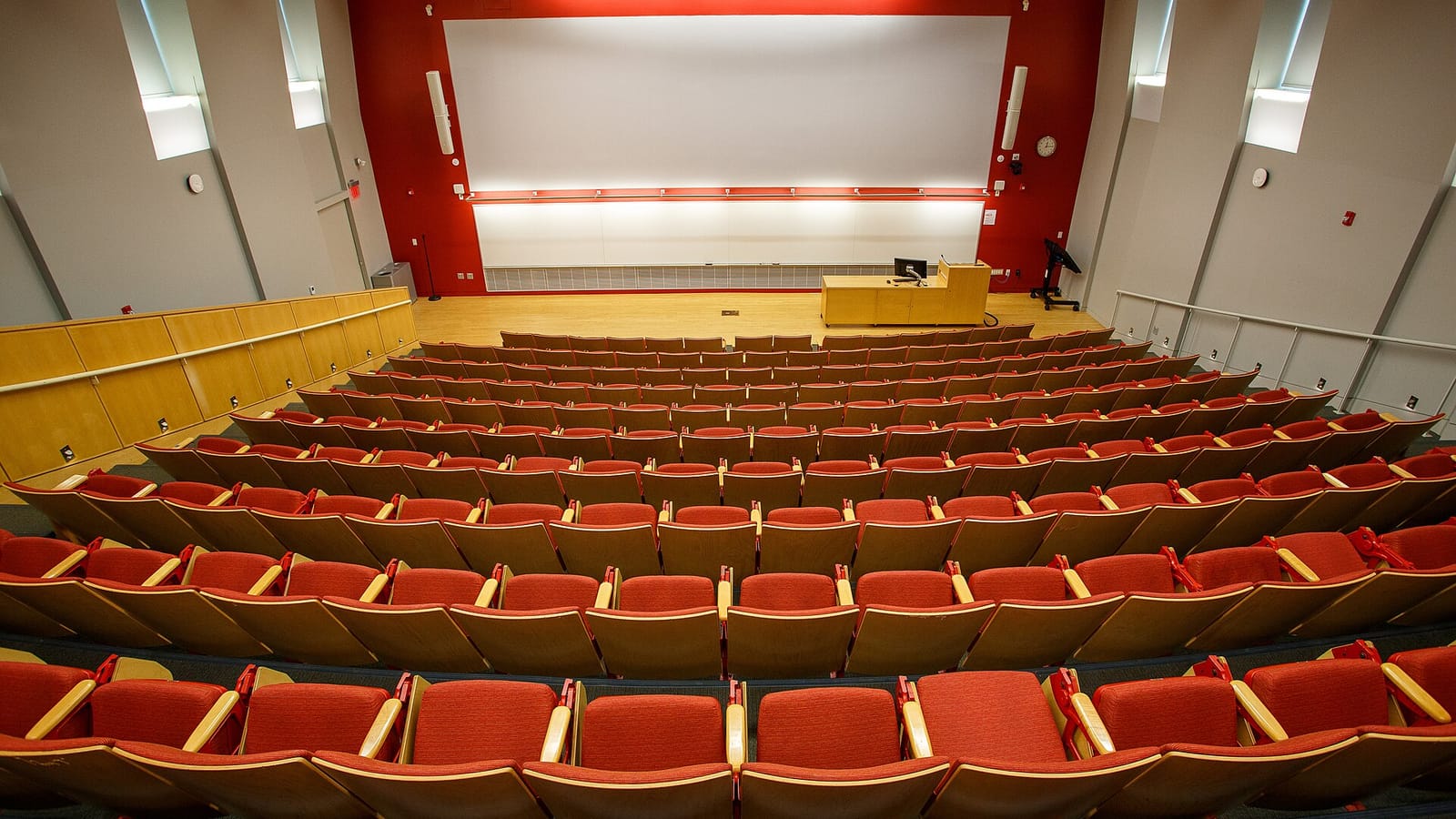 Empty university lecture hall with rows of red seats