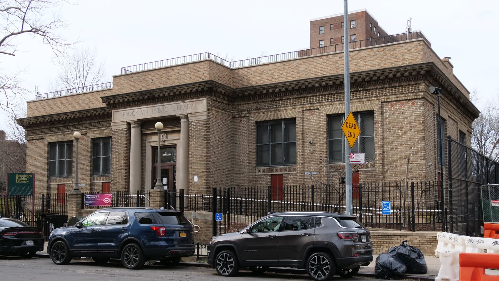 The tan brick Brownsville Library with its columned entrance on Glenmore Avenue, Brooklyn