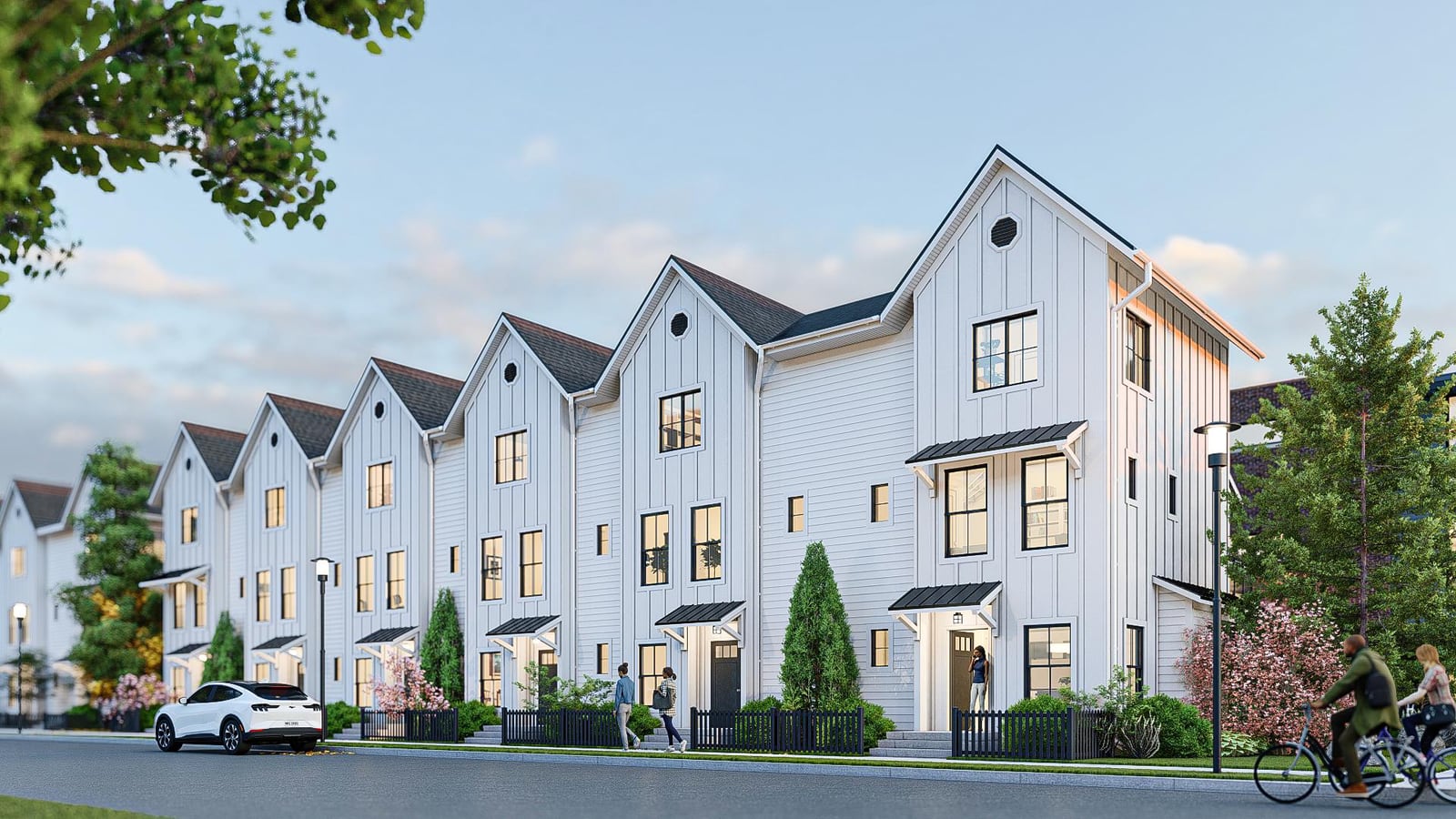 Rendering of a row of white three-story townhomes with steep gabled roofs, black-framed windows and small entry canopies along a street, with a cyclist and people walking