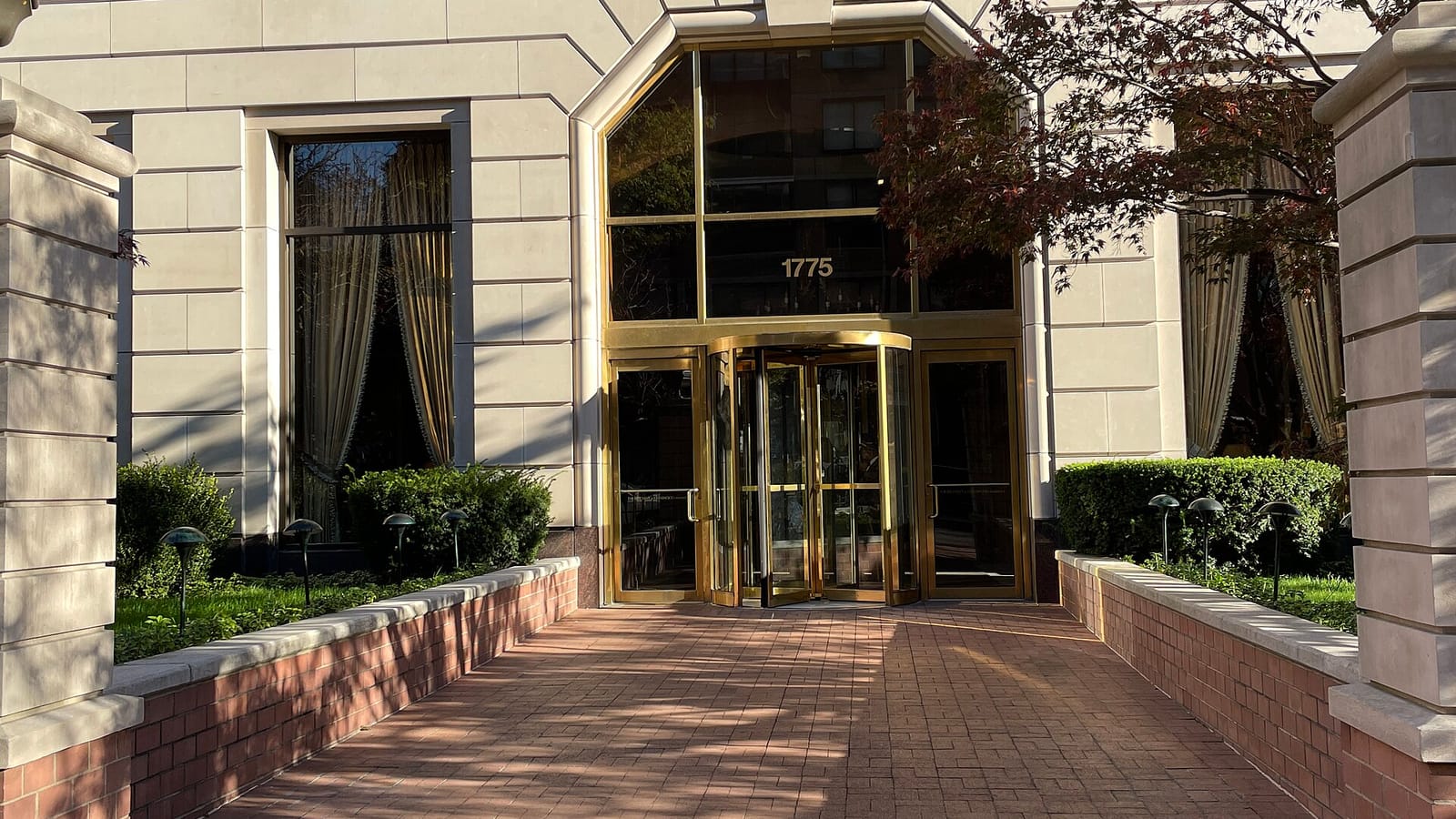 Entrada de un edificio residencial junto a una pequeña plaza
