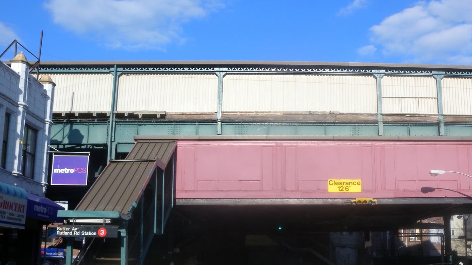 The elevated Sutter Av-Rutland Rd station on the 3 line, with its street stair and station sign