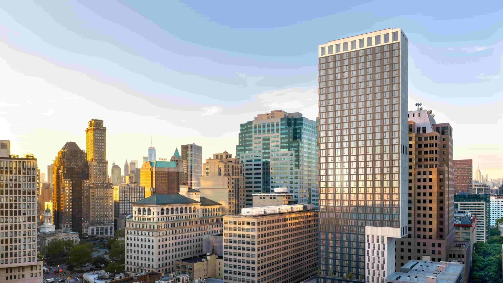 Rendering of a tall, slim apartment tower with a grid of dark windows and a pale band of tall openings at its top, standing among older office buildings in Downtown Brooklyn at sunrise, with a pale section of the tower stepping out above a lower building beside it and the Manhattan skyline in the distance
