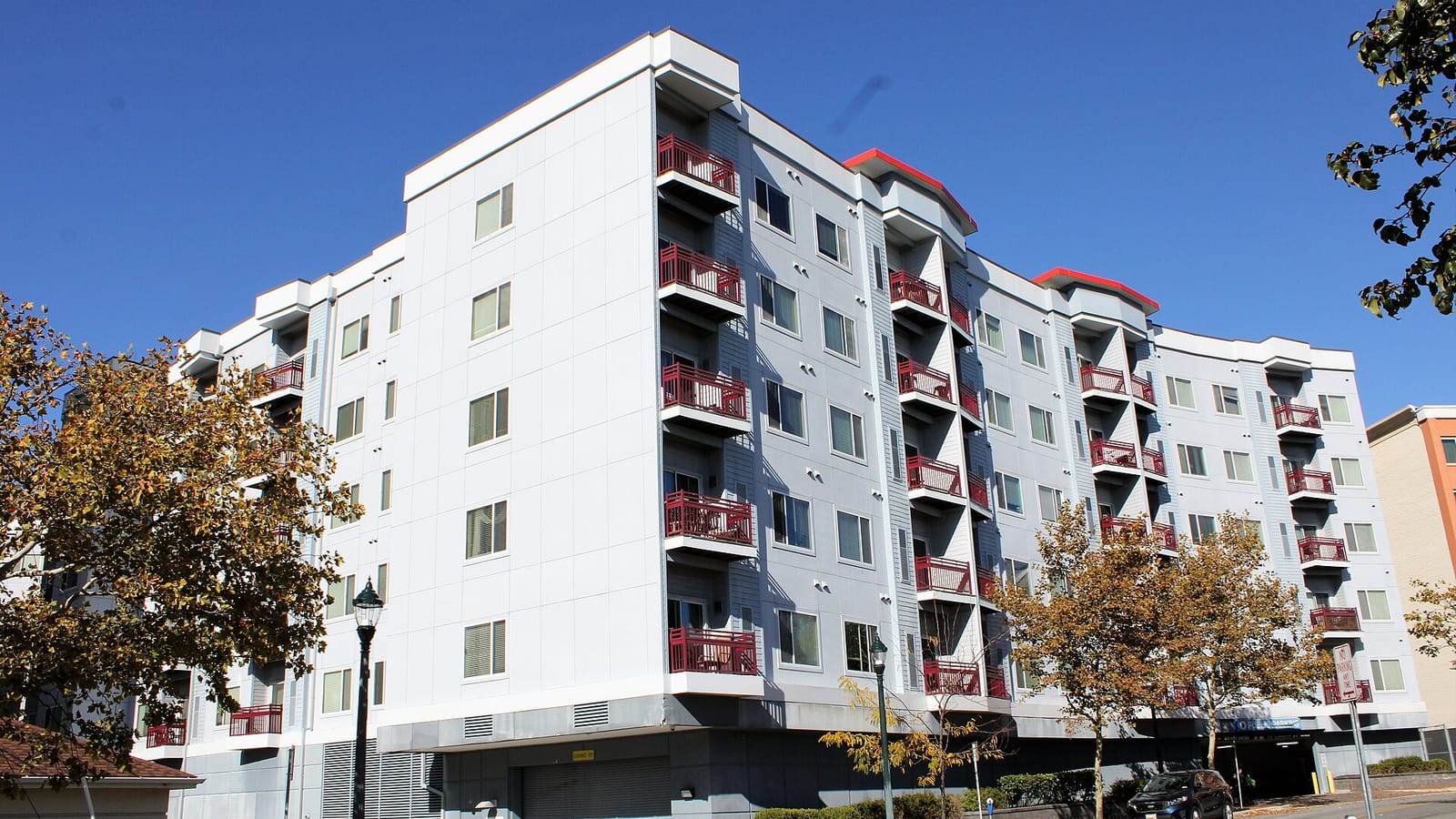 Pale apartment building with red balcony accents