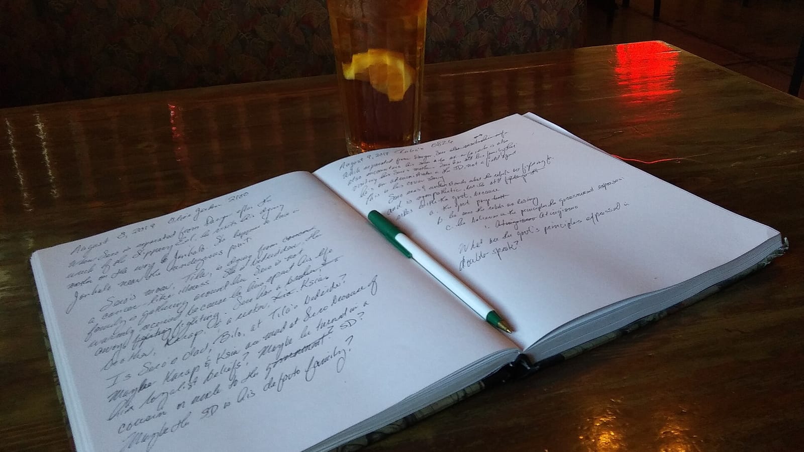 Open notebook with handwritten notes and a pen