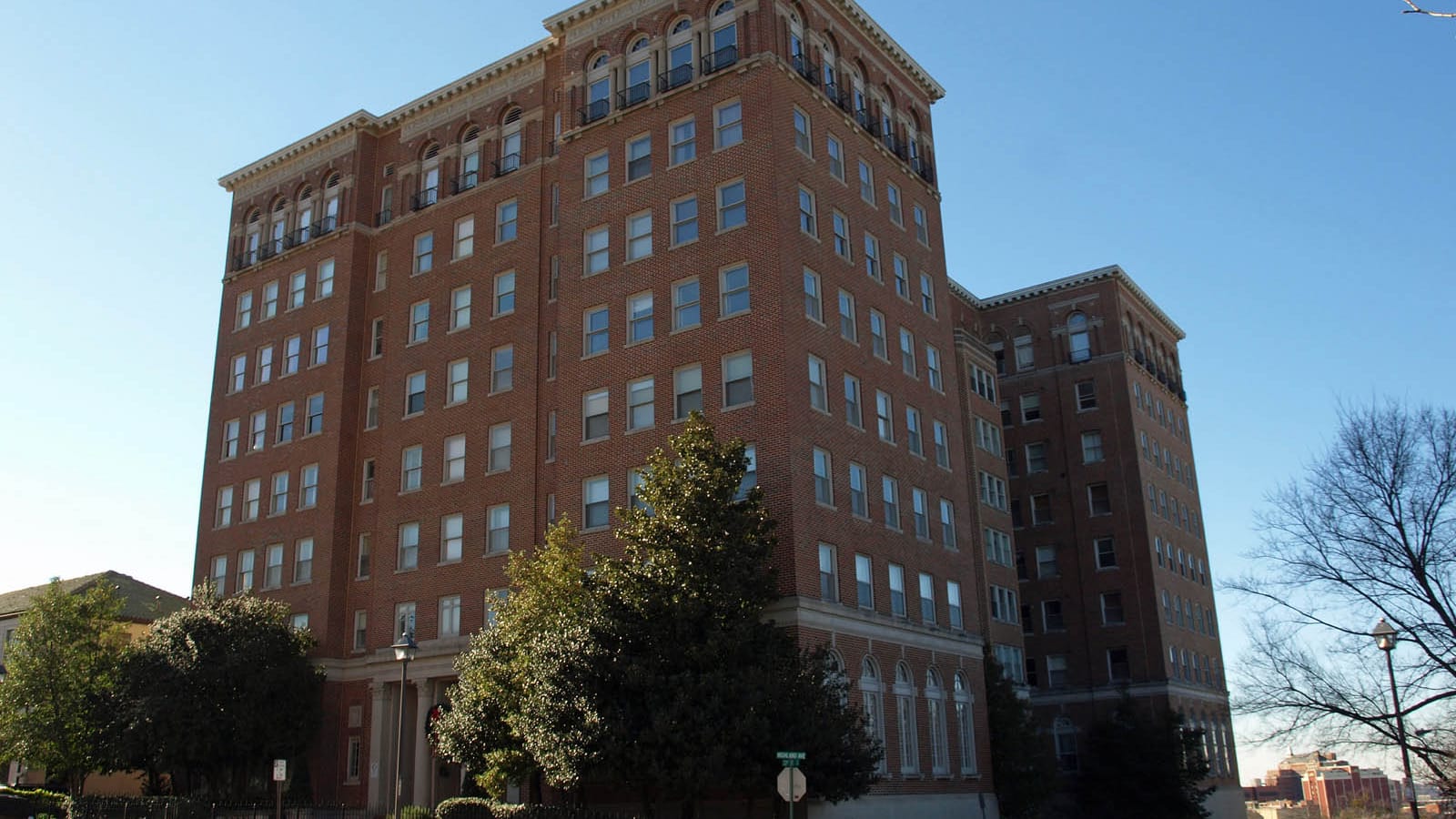 Tall brick apartment building with a projecting entrance and rows of windows