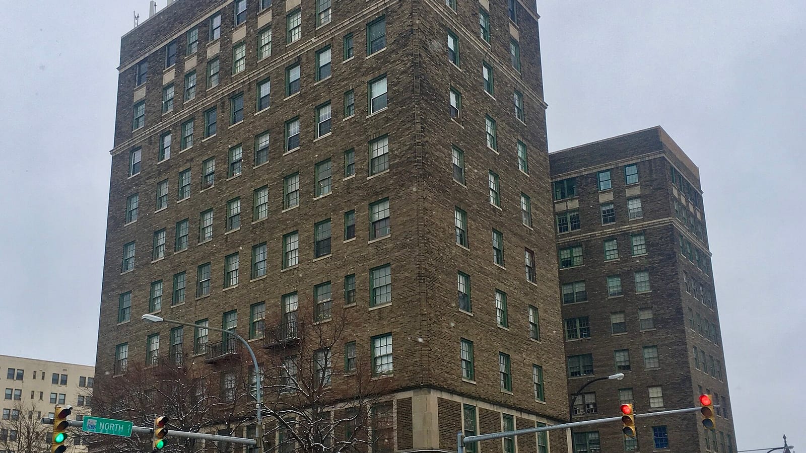 Tall brick apartment building at a street corner