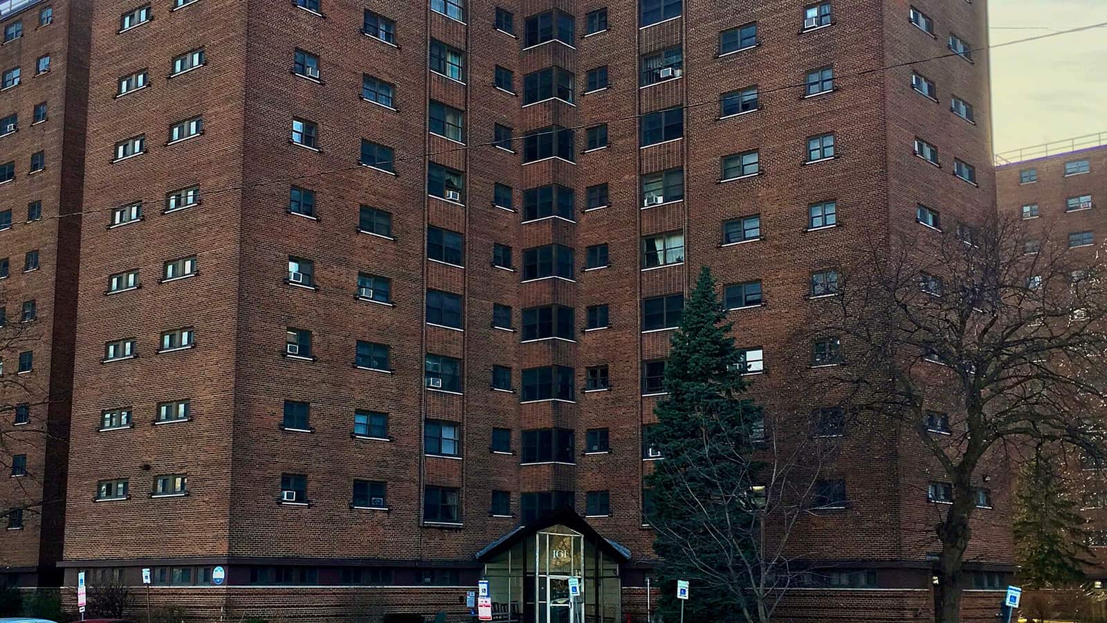 Brick apartment wings framing a small glazed entrance