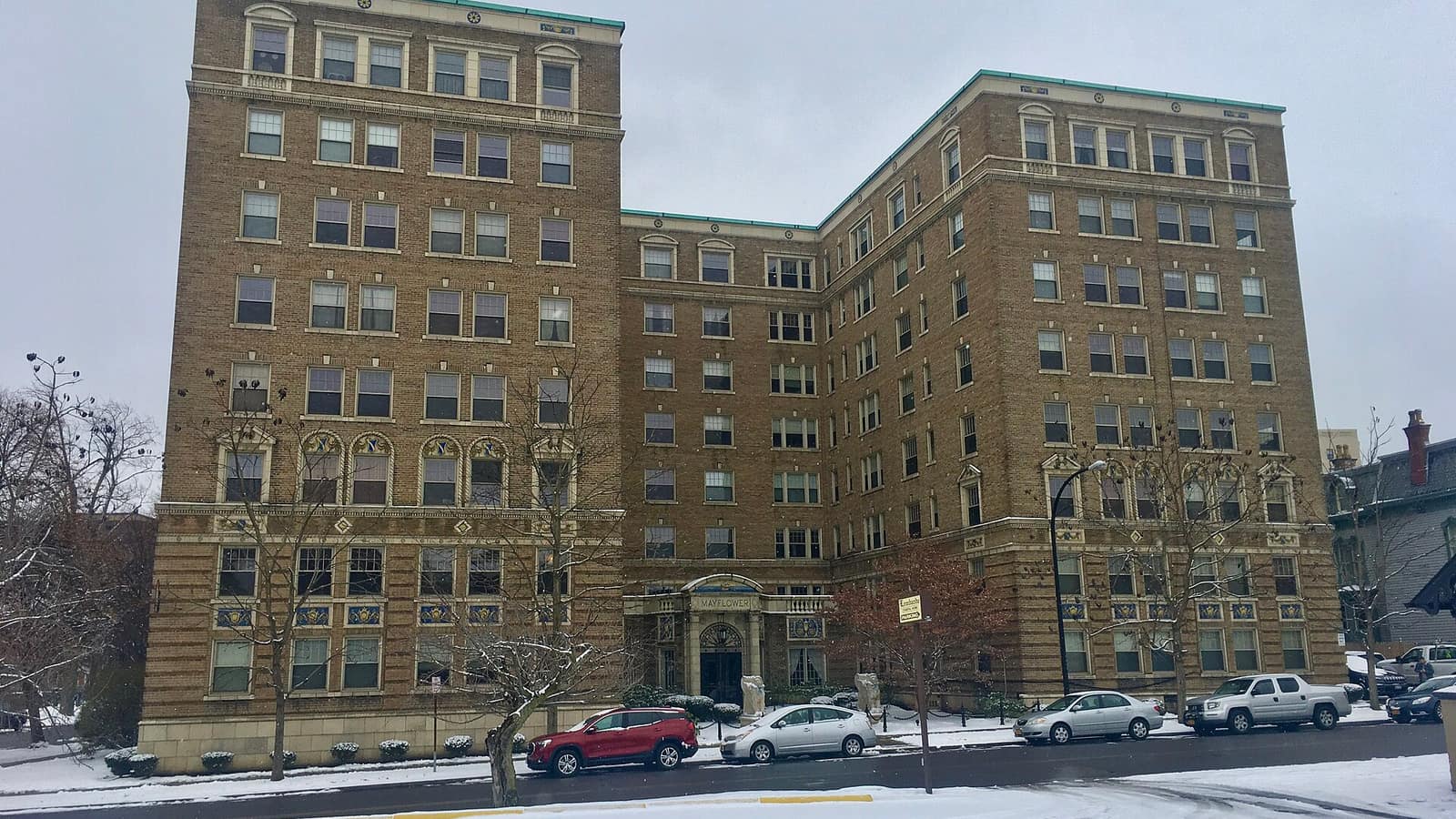 Large tan brick apartment building with two wings and a central entrance