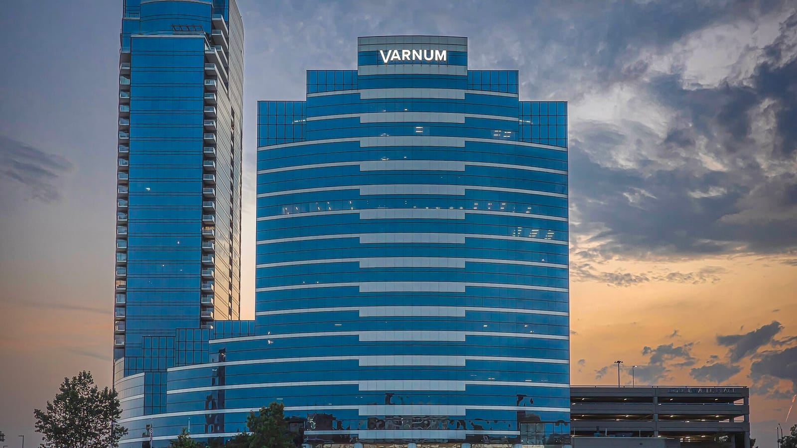 Two blue glass towers against an evening sky