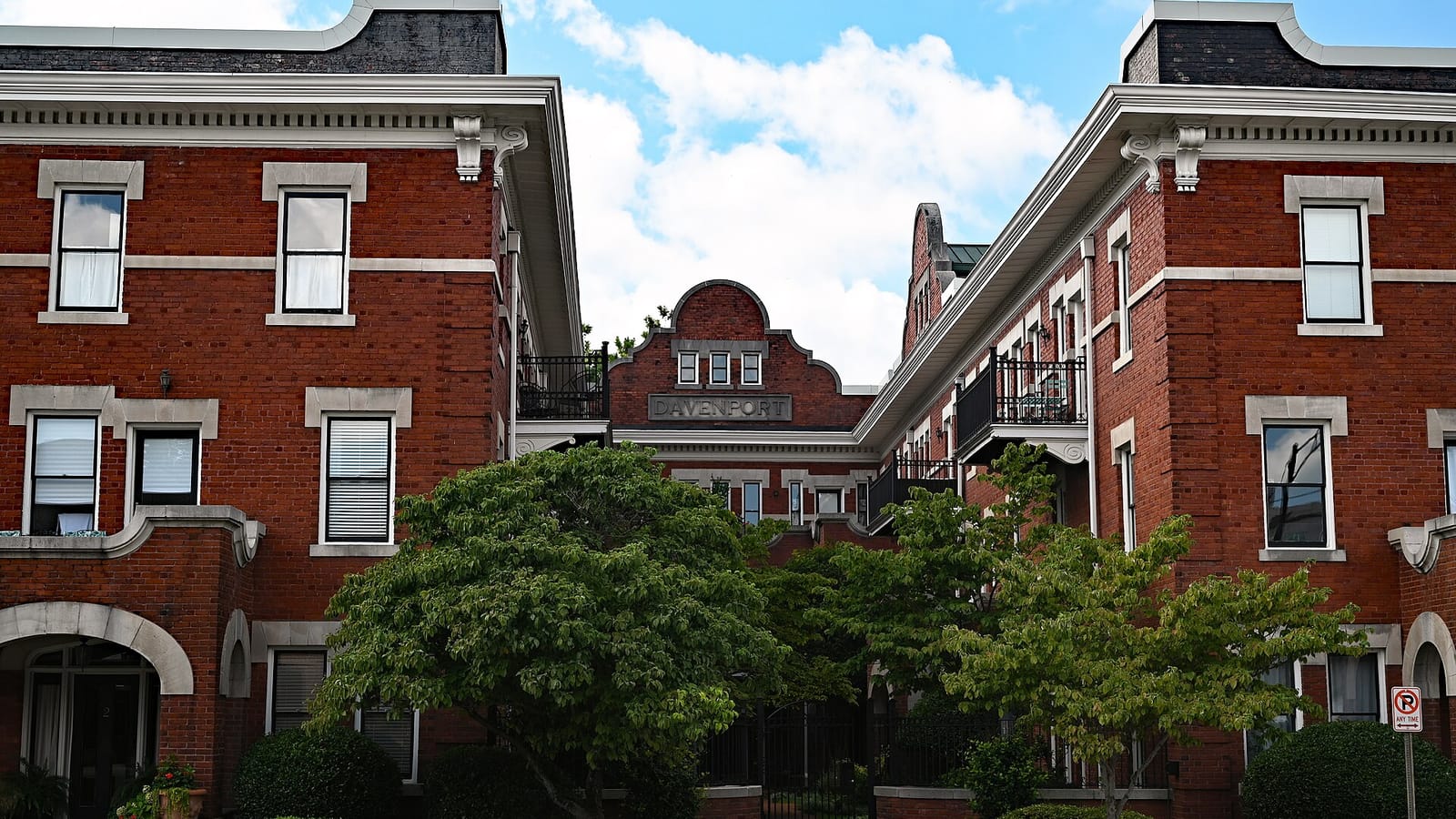 Red brick apartment wings framing an inner garden