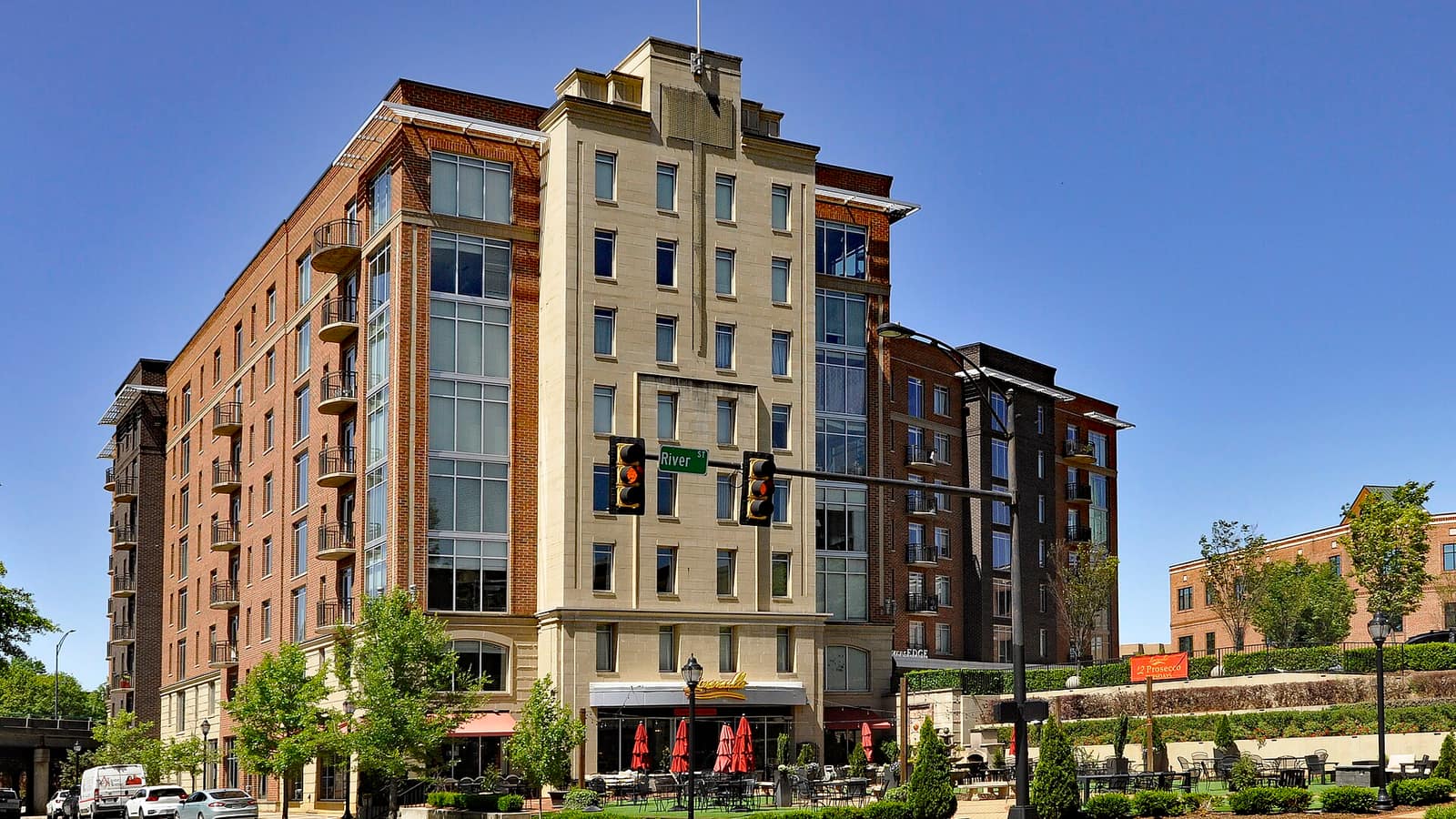 Modern apartment building with a tan corner tower and rows of balconies