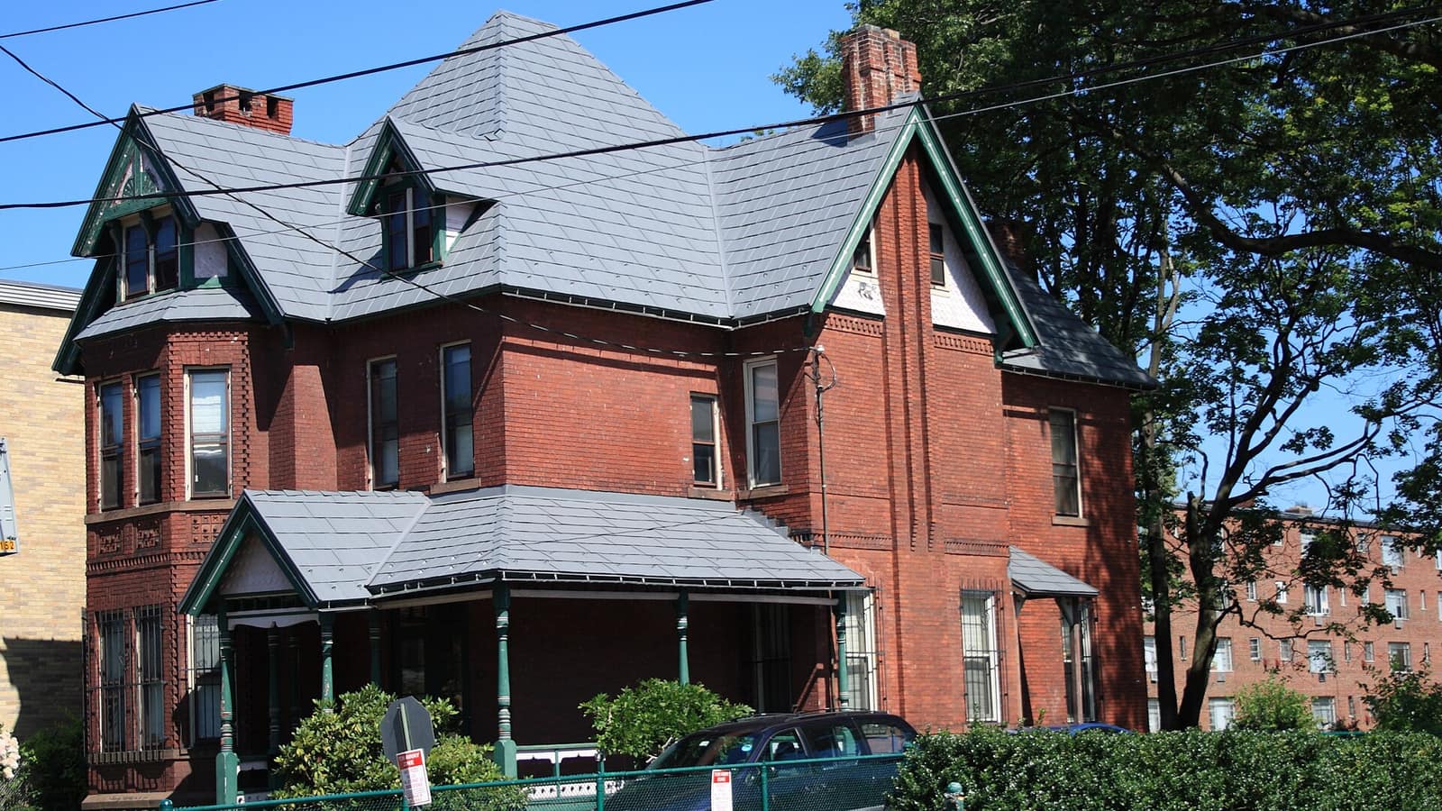 Red brick house with steep roof gables and a covered porch