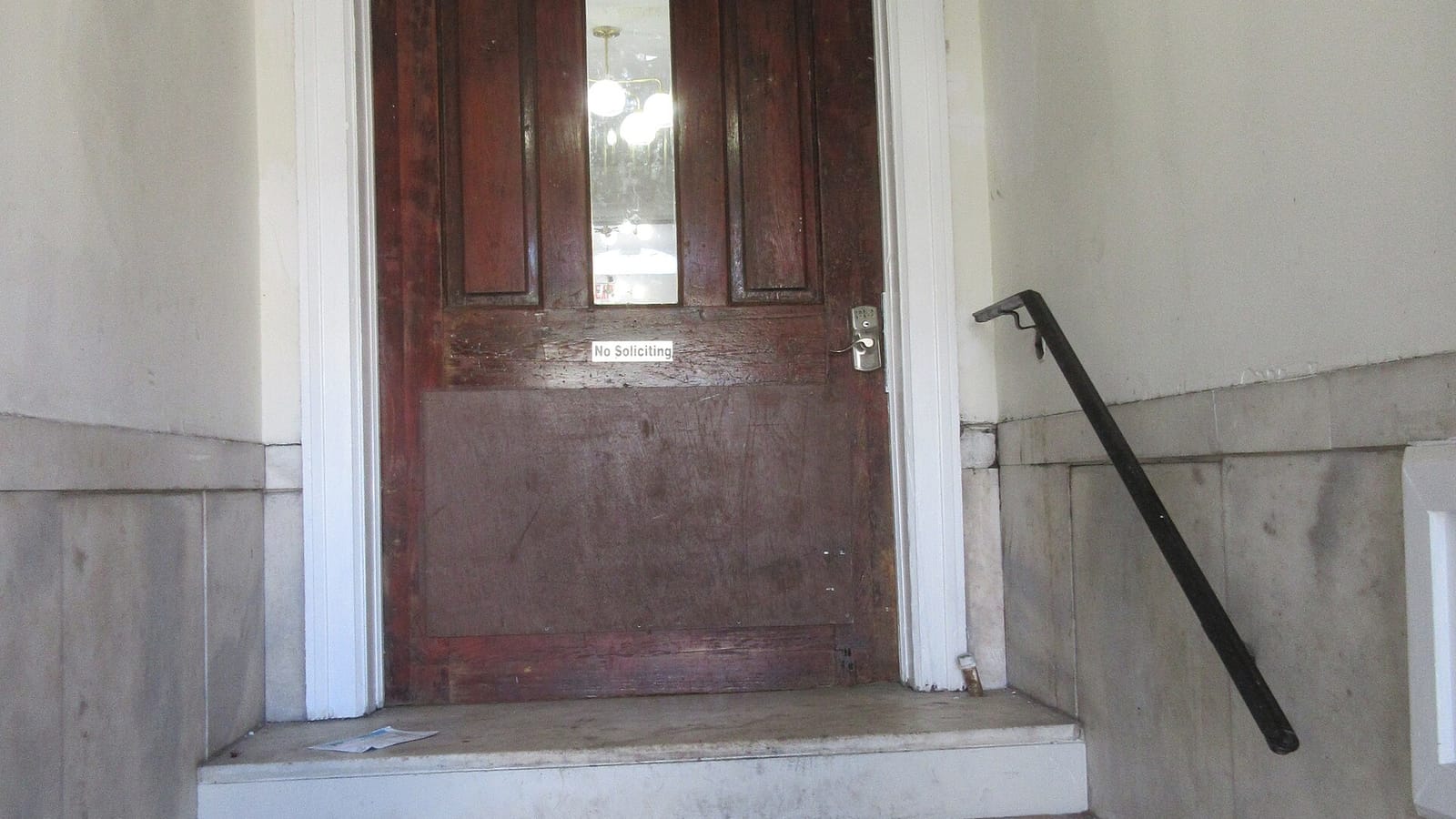 Wooden apartment door above a short flight of stone steps