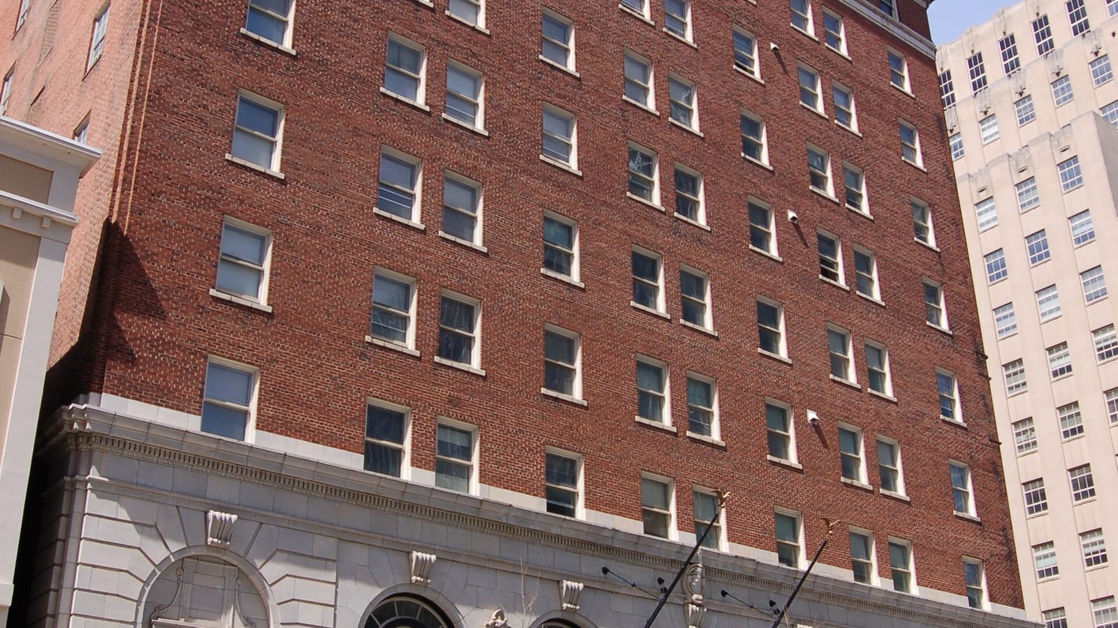 Tall red brick building with a pale stone base