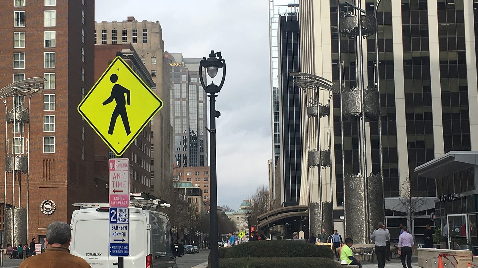 Downtown street with tall buildings, streetlights and a pedestrian crossing