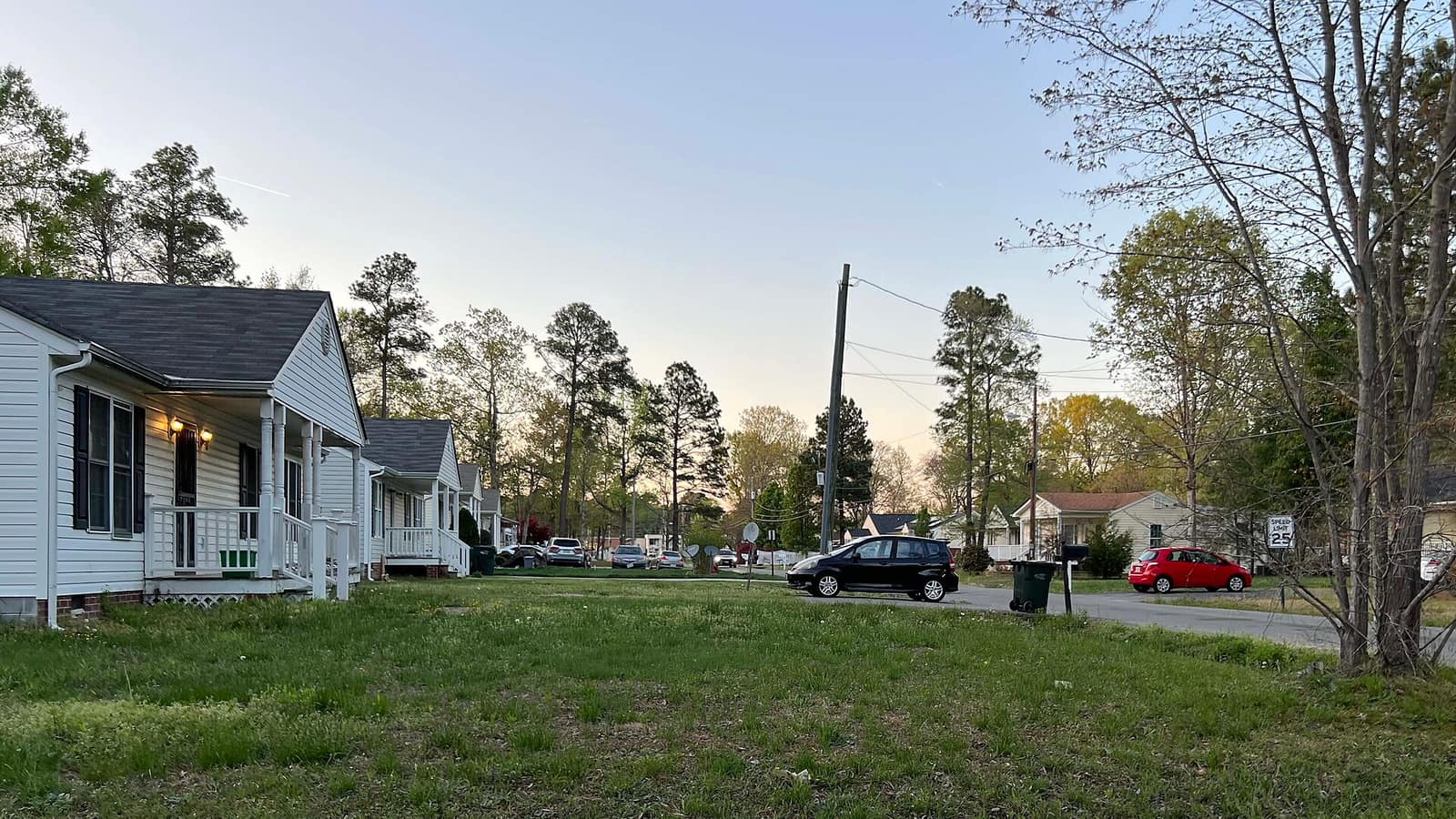 Small homes with covered porches beside front lawns along a residential street