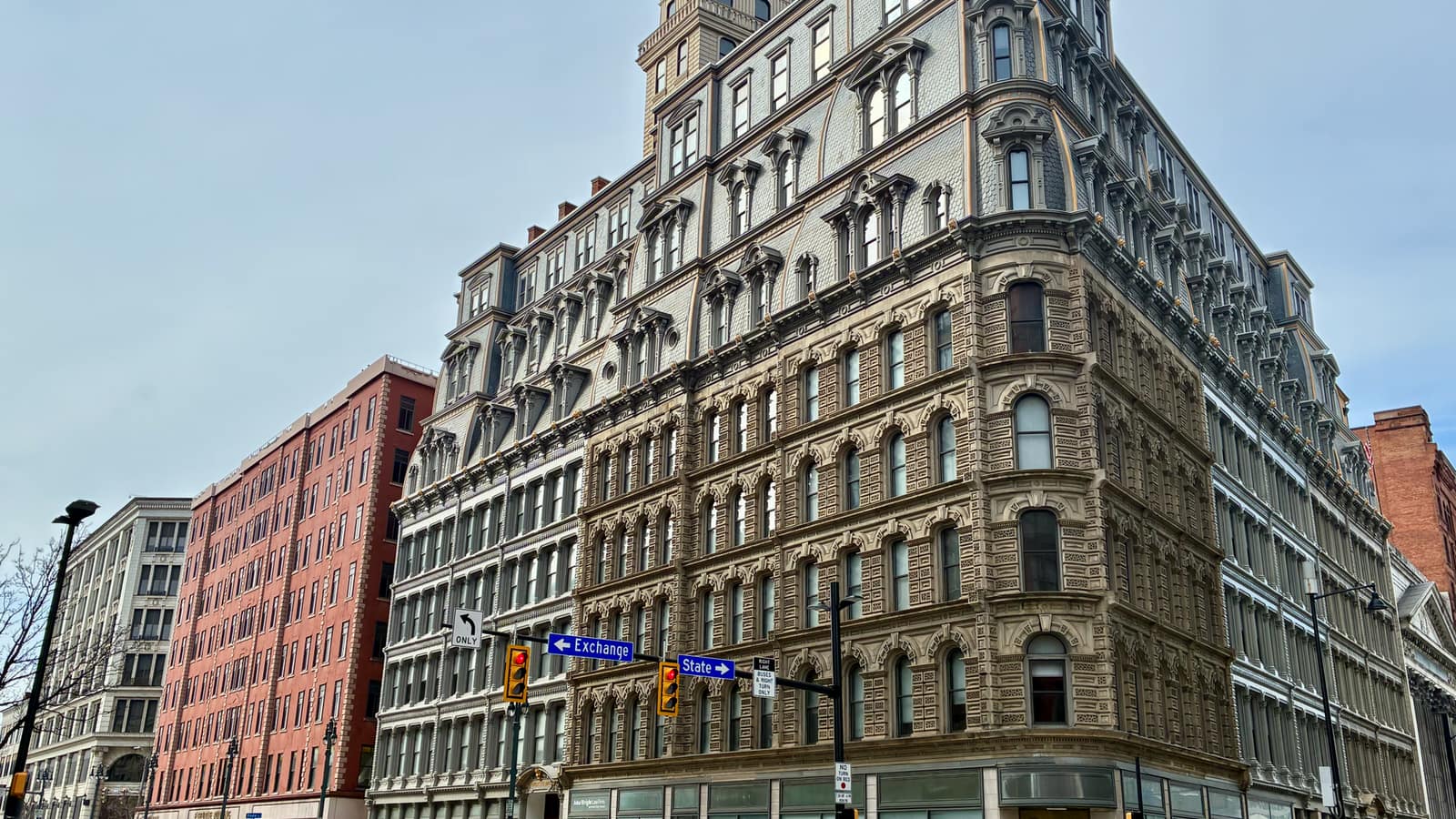 Ornate multistory building at an intersection beside other downtown buildings