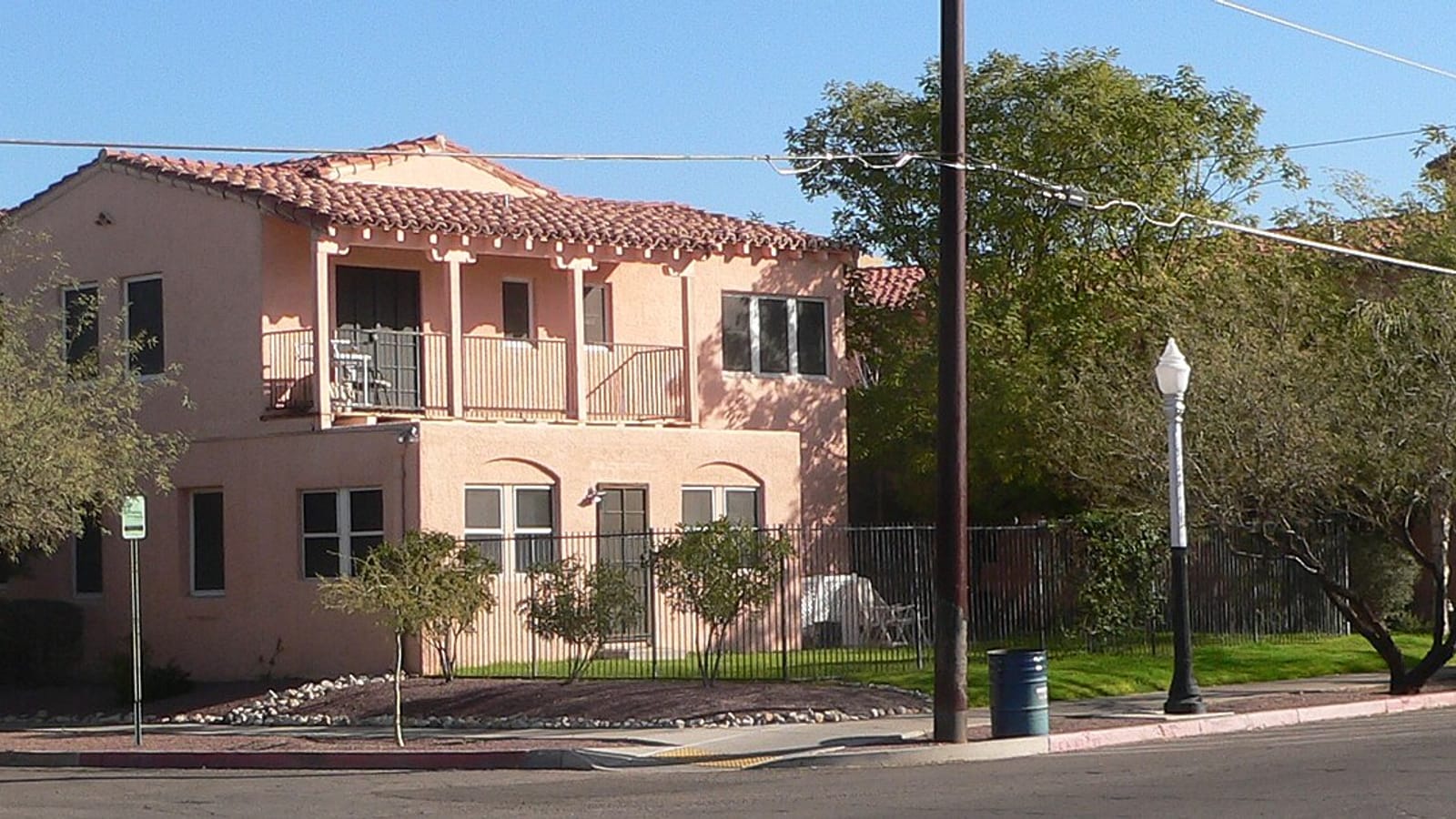 Covered balconies and a tiled roof on a peach stucco apartment building