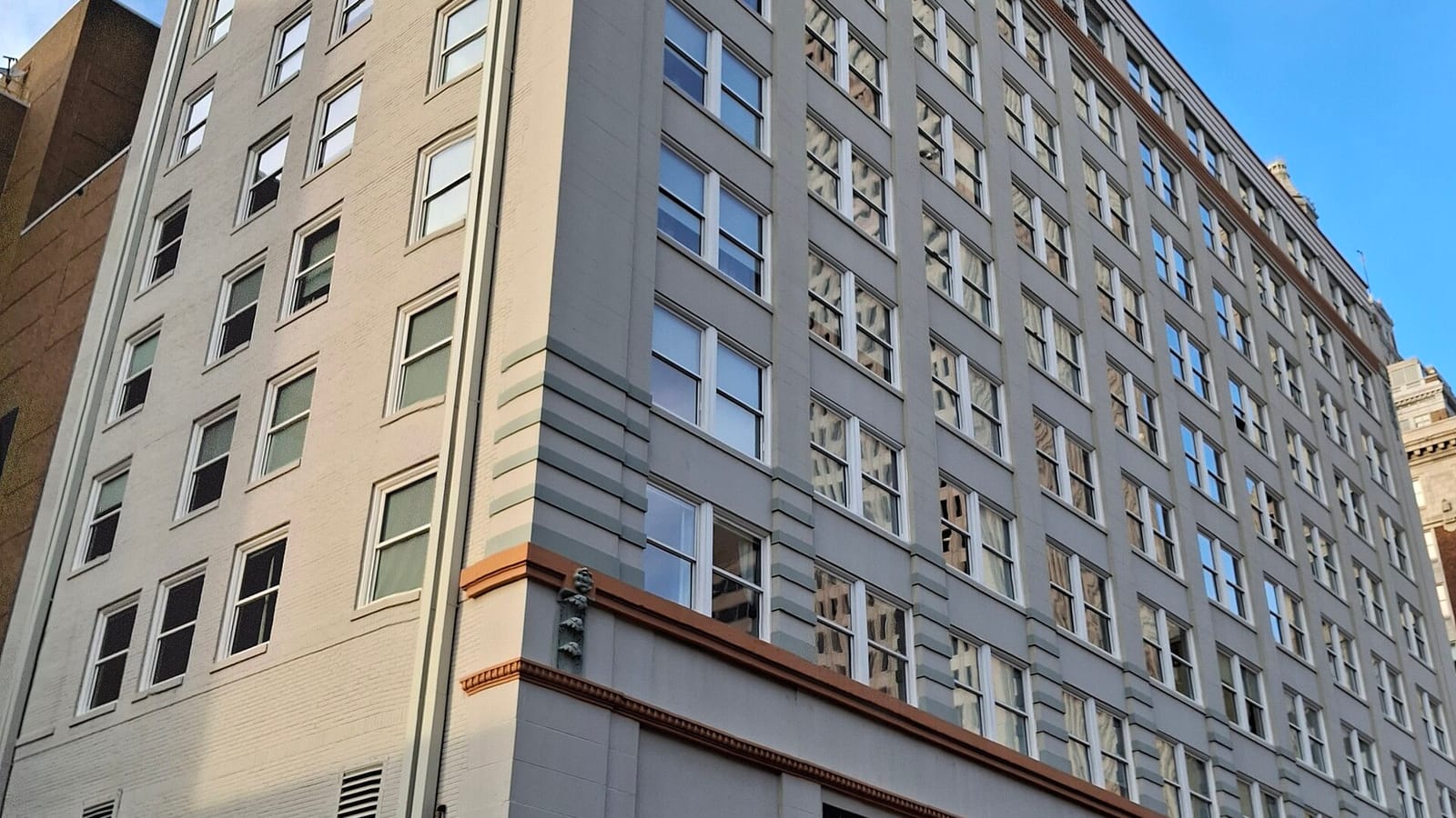 Pale multistory apartment facade with small rectangular windows
