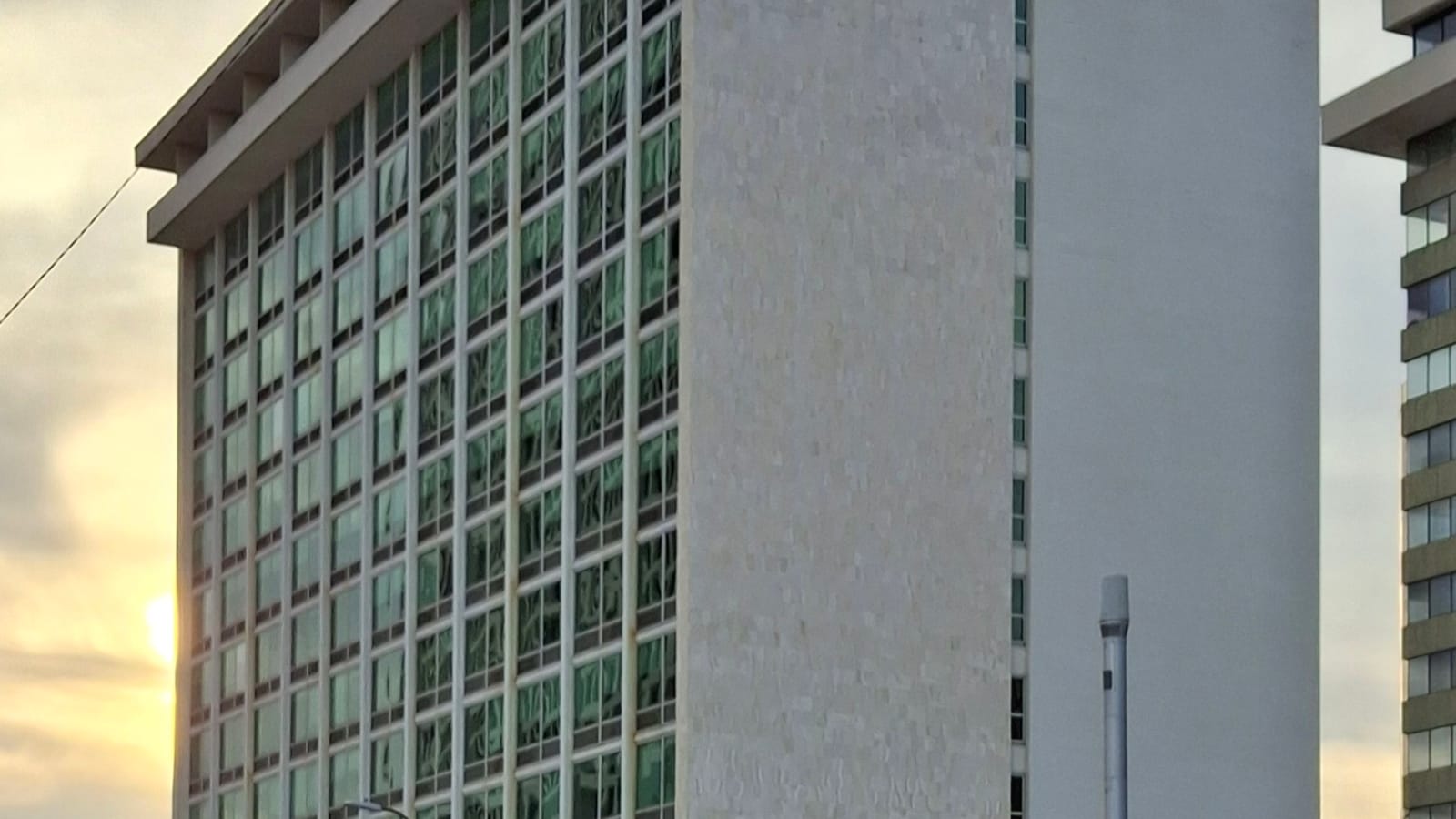 Balconies and rows of windows on a pale high-rise apartment facade