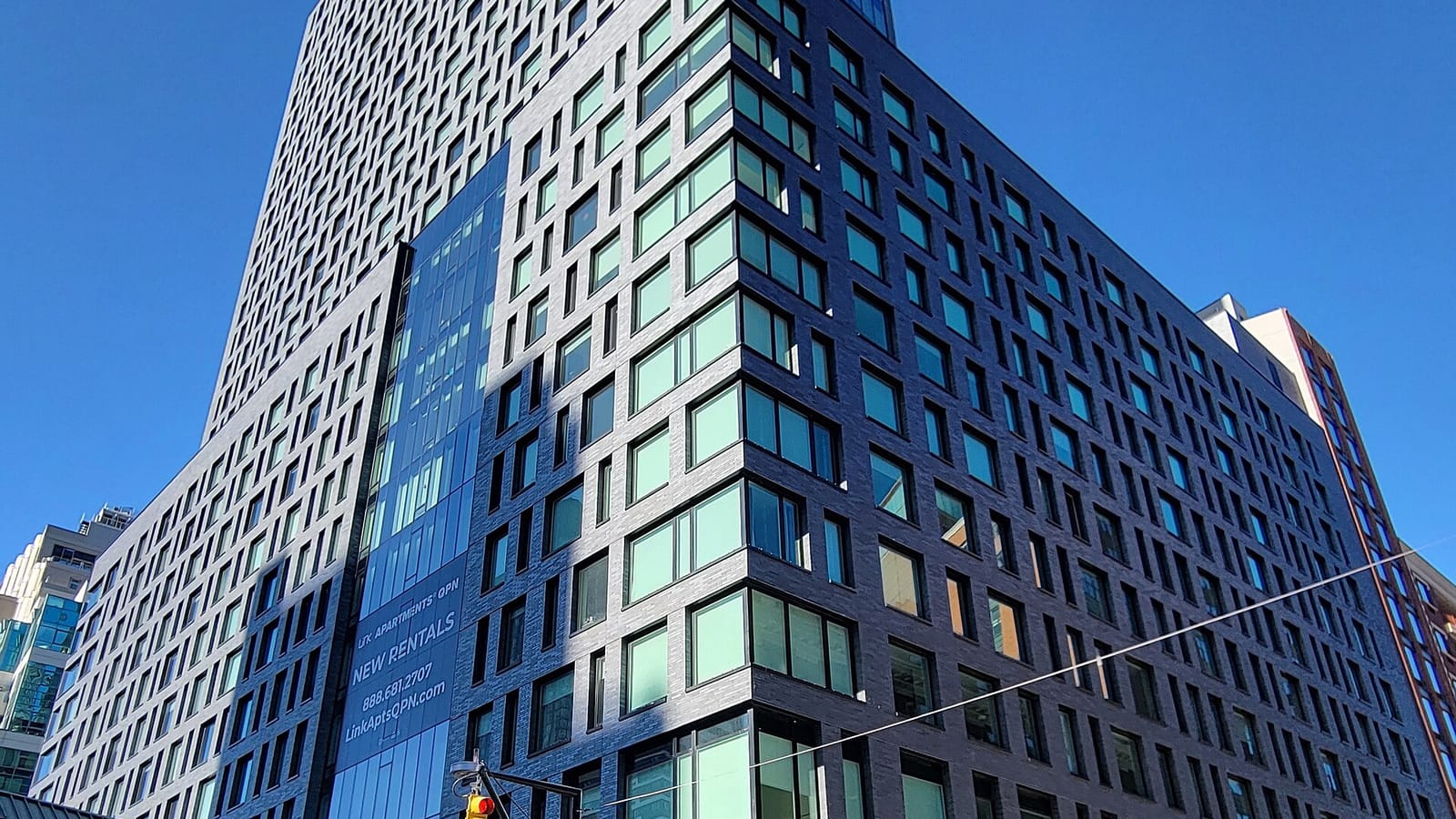 Modern apartment facade rising above a city street