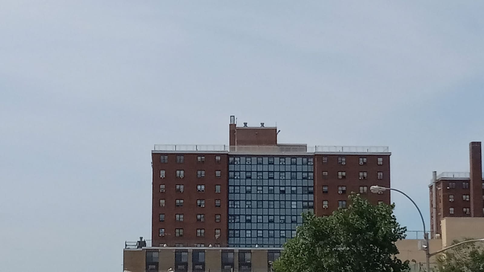 Red-brick public housing towers against a grey sky