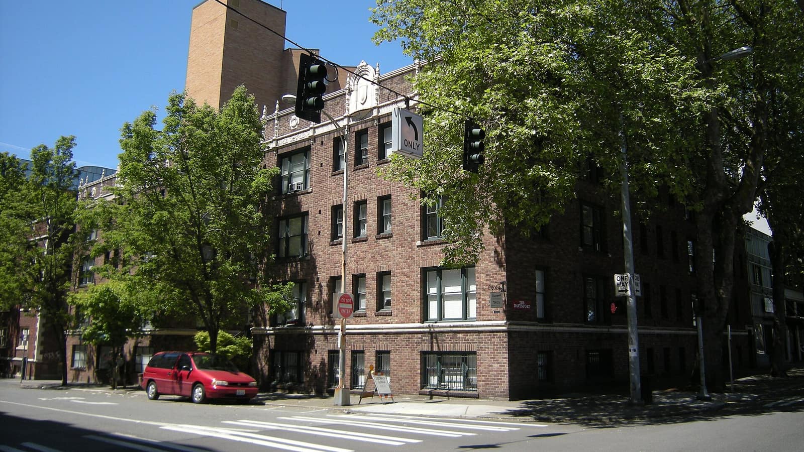 Brick apartments at a tree-lined street corner