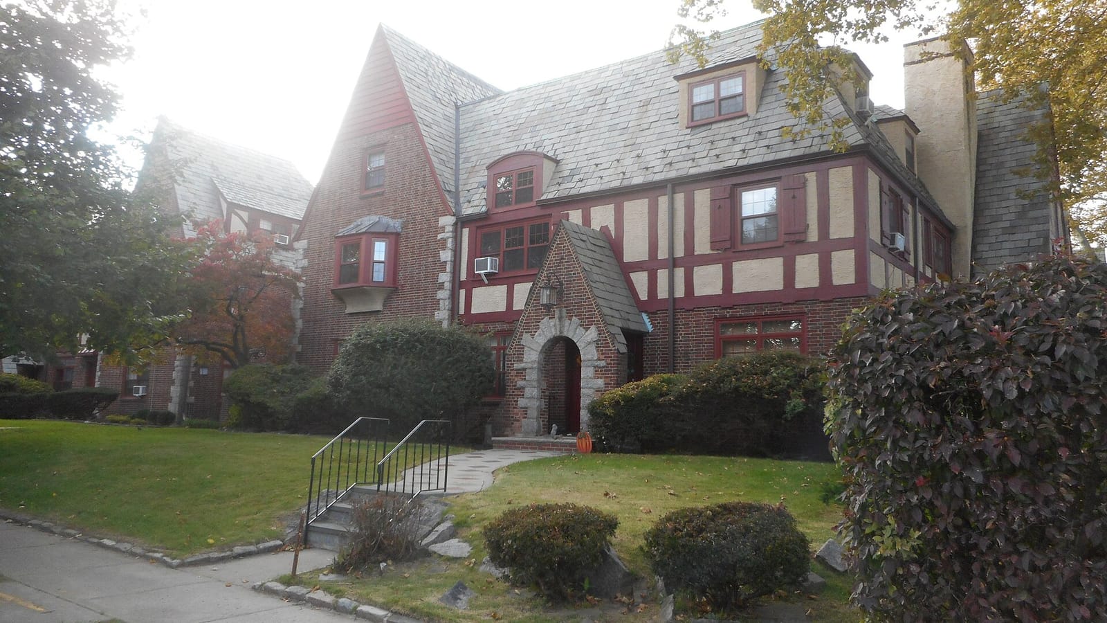 Tudor-style apartments beside a landscaped lawn