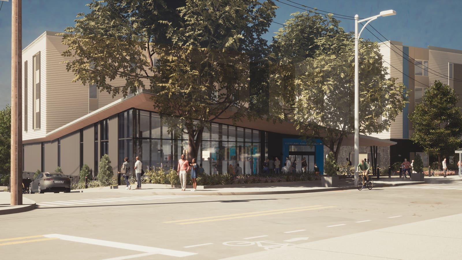 Rendering of a library with a glass front and a low sloping roof at a street corner, shaded by trees, with apartment floors behind and a bus shelter at the right