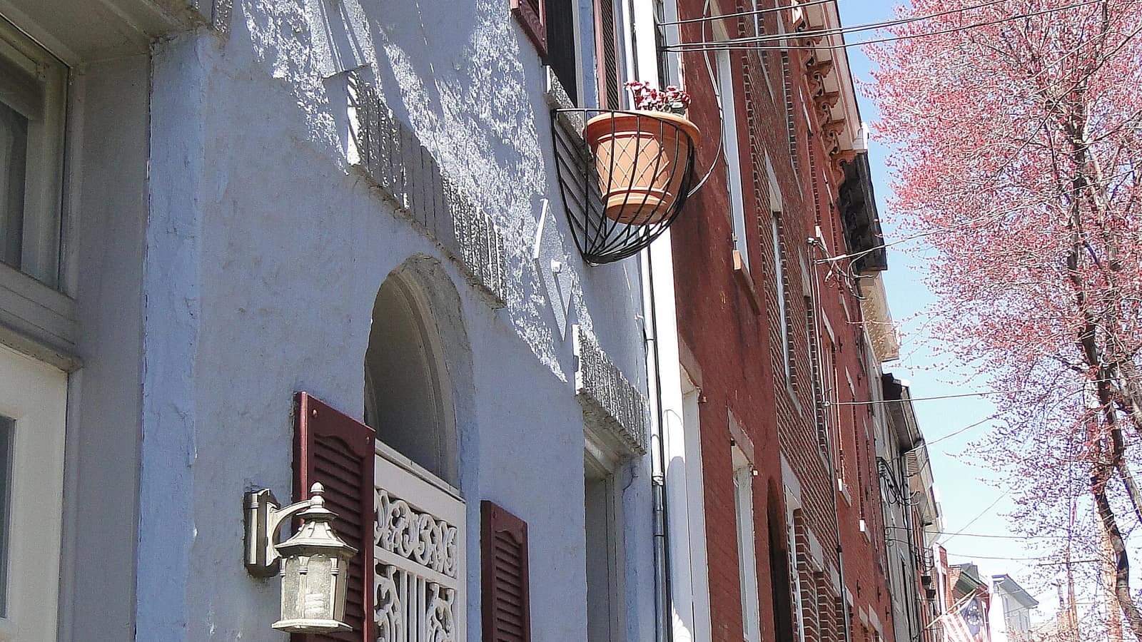 Rowhouse facades beside a narrow sidewalk