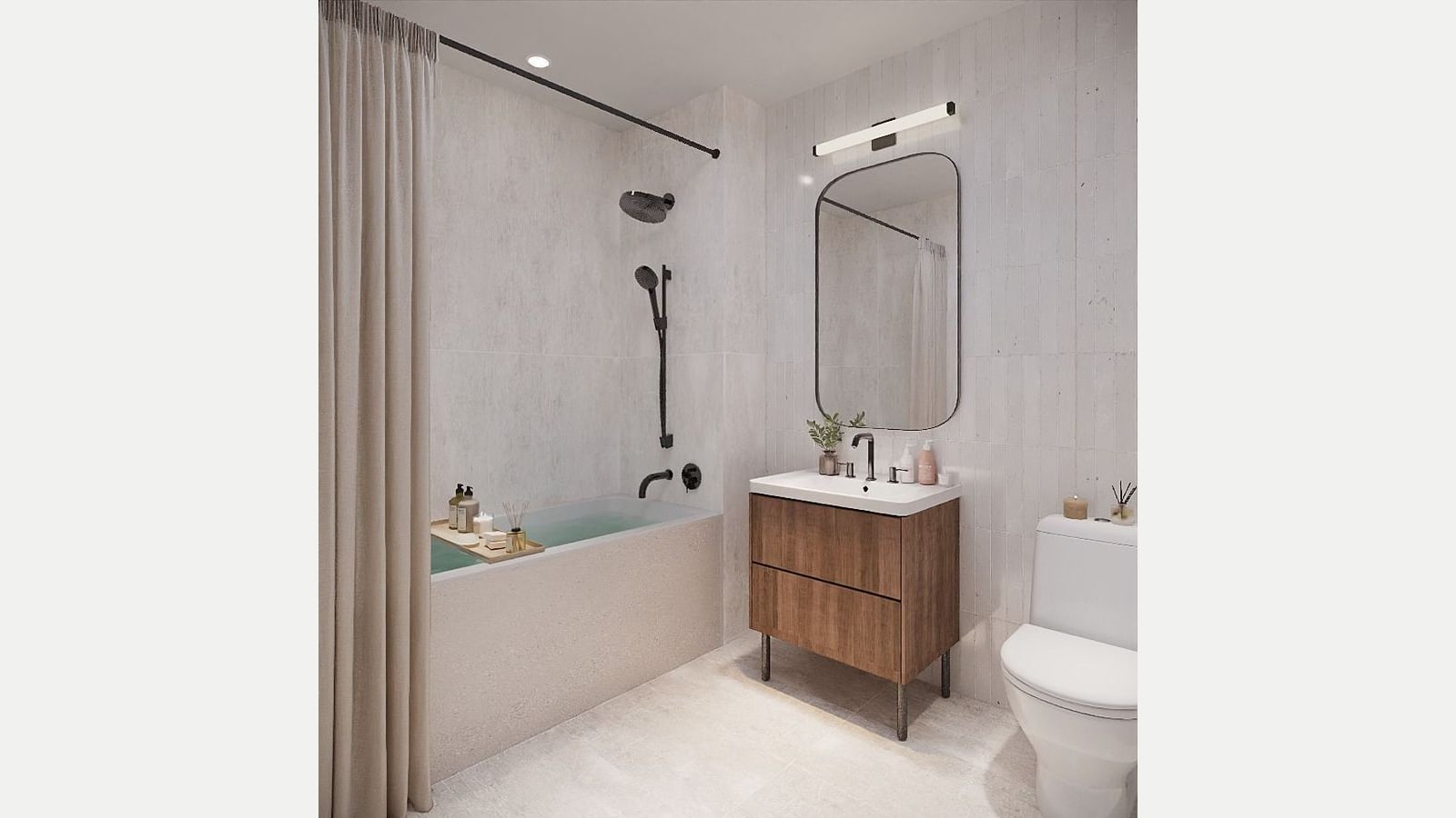Rendering of a bathroom with pale stone-look tile walls and floor, a tub with a shower head, hand shower and beige curtain, a wood vanity with a white sink, a rounded mirror under a light bar, and a white toilet