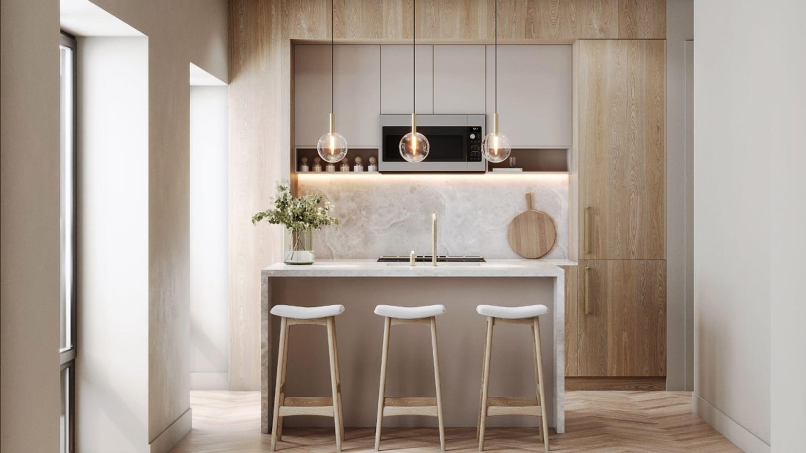 Rendering of a kitchen with pale wood and grey cabinets, a built-in microwave, a stone backsplash, an island with a sink, a brass faucet and three stools, three globe pendant lights and a herringbone wood floor