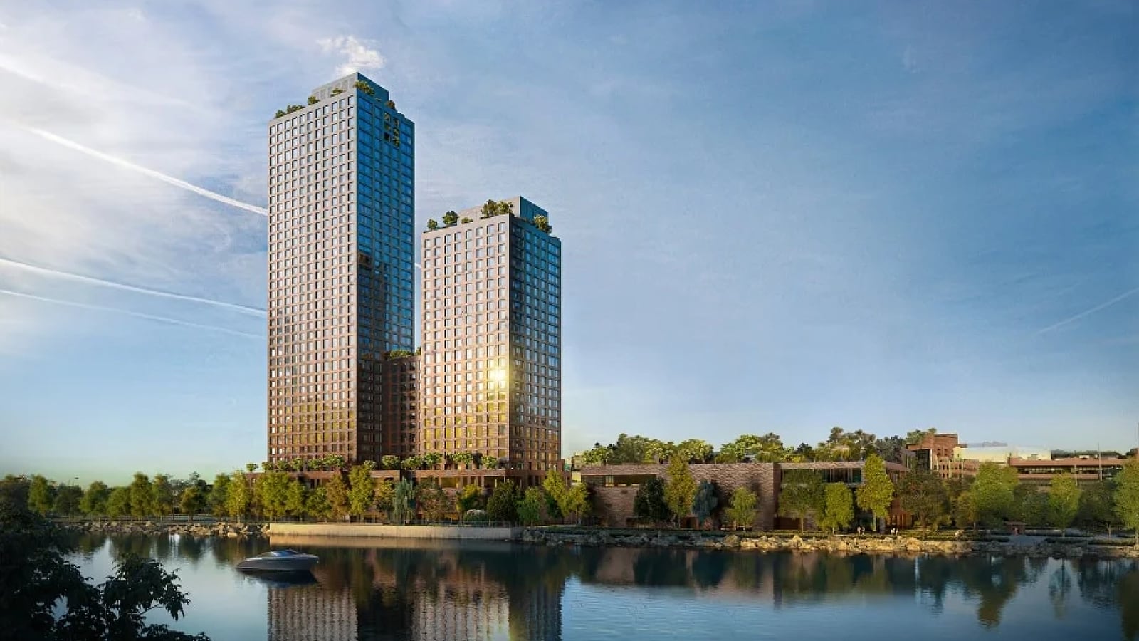 Rendering of two dark-fronted apartment towers of different heights with planted roof terraces, joined by a lower section, rising behind a tree-lined riverbank, with a small boat on the water in the foreground and low brick buildings to the right