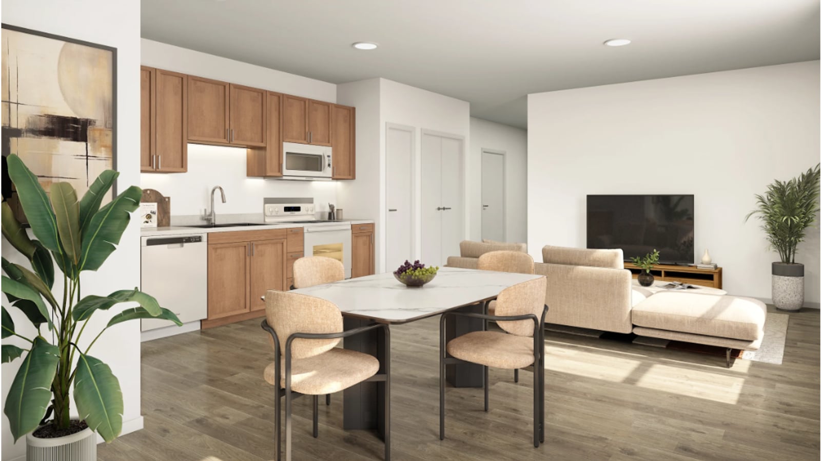Image of an open kitchen and living room with wood cabinets, white appliances, a dining table with four chairs and a pale sofa